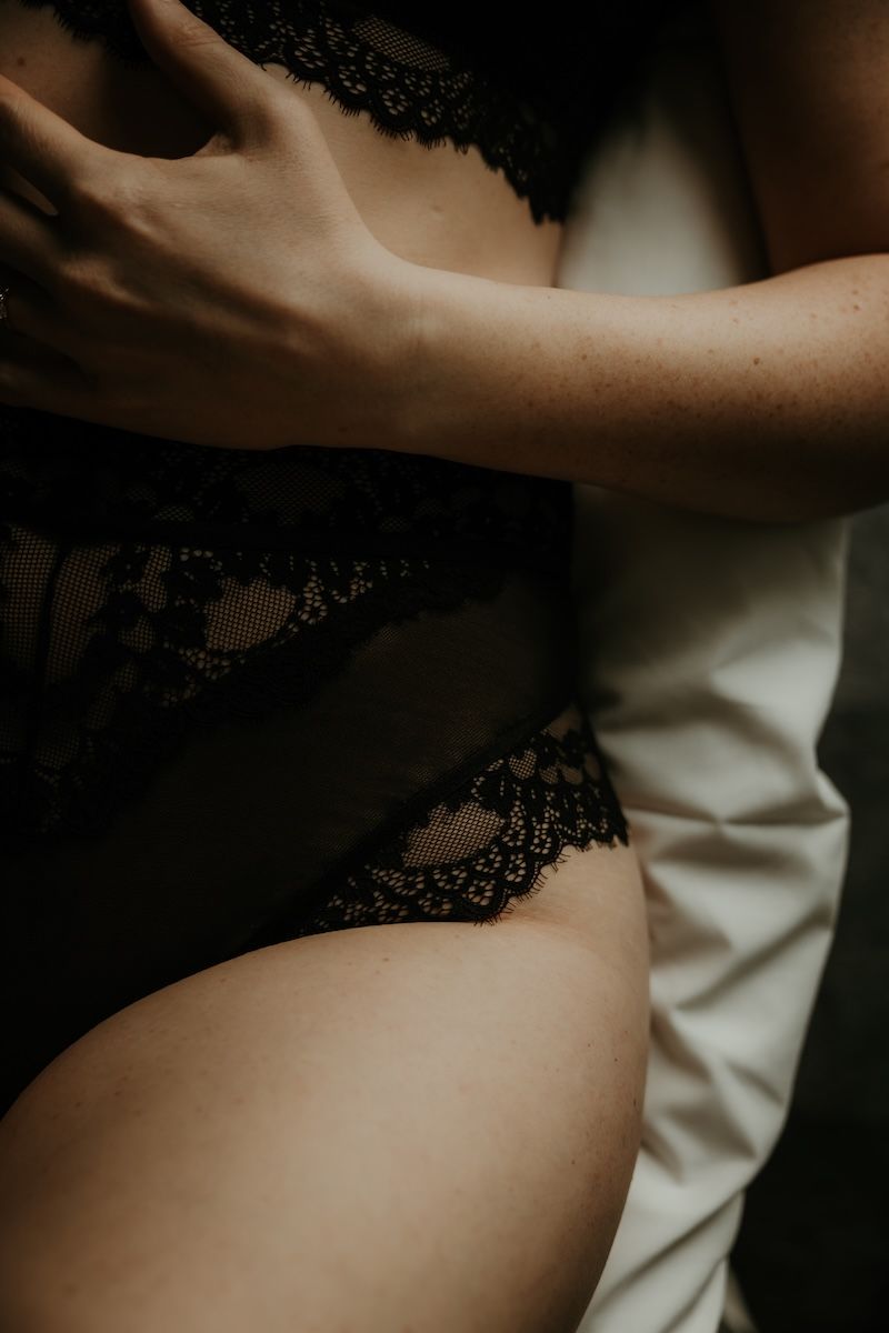 Närbild på en kvinnas höft iklädd svarta spetstrosor från en boudoirfotografering i Skåne. Foto: Grevholm Photography.