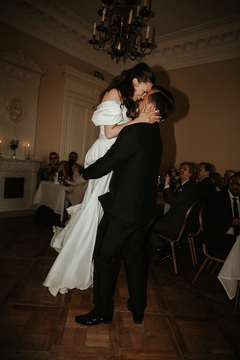 Brudgum lyfter upp brud under första dansen på deras bröllop på Överås slott i Göteborg. Foto: Grevholm Photography