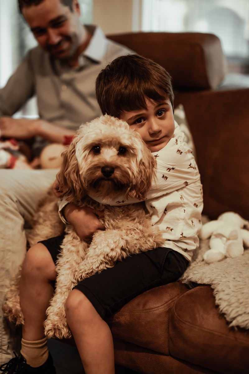 En liten pojke kramar om sin hund under en lifestylefotografering i Skåne med Grevholm Photography