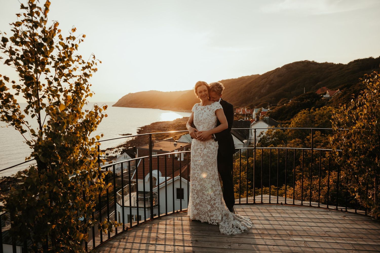Brudpar står på balkongen på Grand Hotel Mölle i solnedgången. Foto av Grevholm Photography.