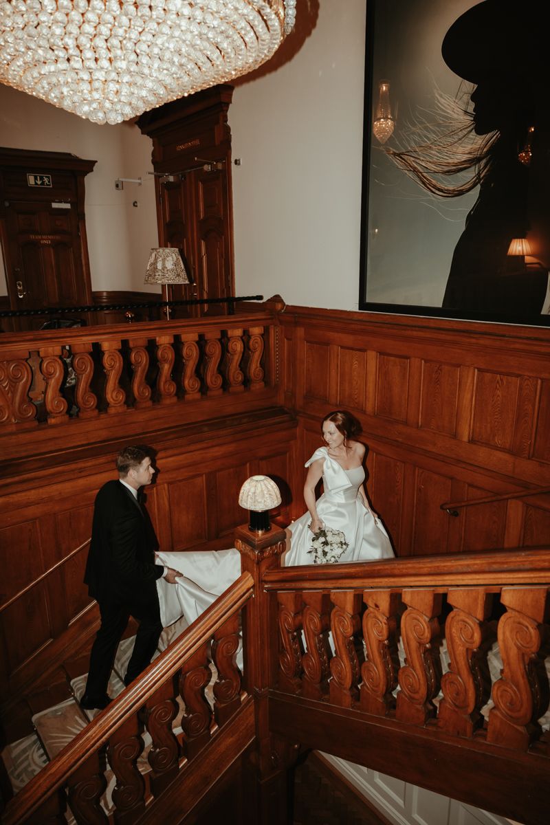 Brudpar går upp för trappan under deras bröllop på Maryhill Estate fotograferat av Grevholm Photography.