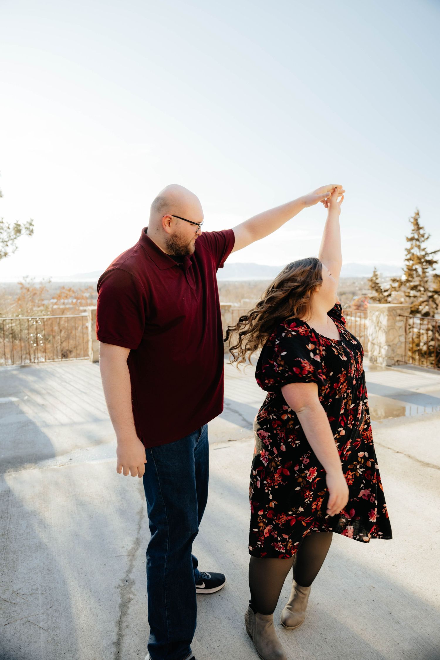 Couple dancing together on a snowy winter day with mountains in the background.