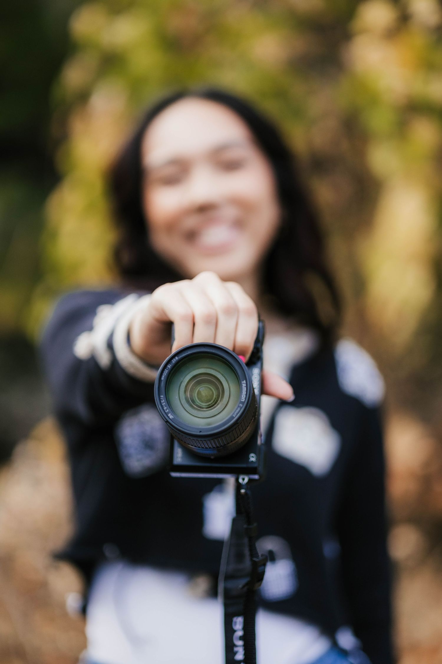 Close-up shot of photographer holding camera with bokeh background.
