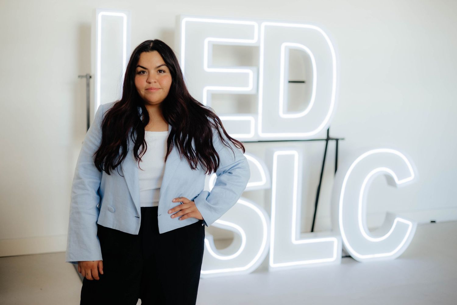 Modern portrait series with glowing LED sign backdrop.