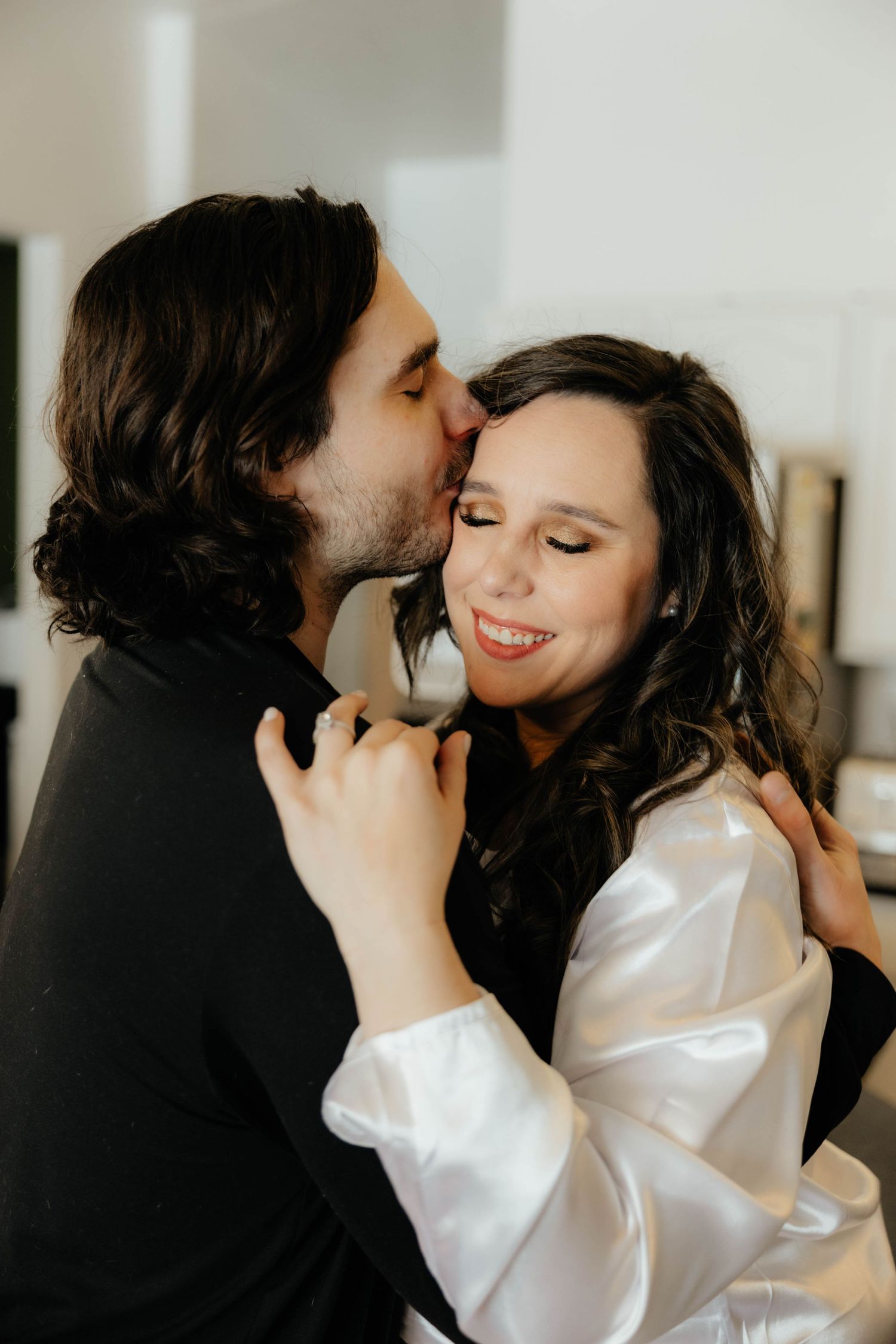 Romantic indoor portrait of couple sharing tender moment in intimate setting.