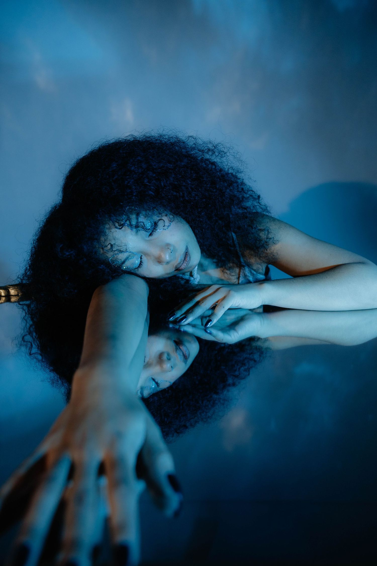 Artistic portrait with blue lighting creates dramatic silhouette effect.