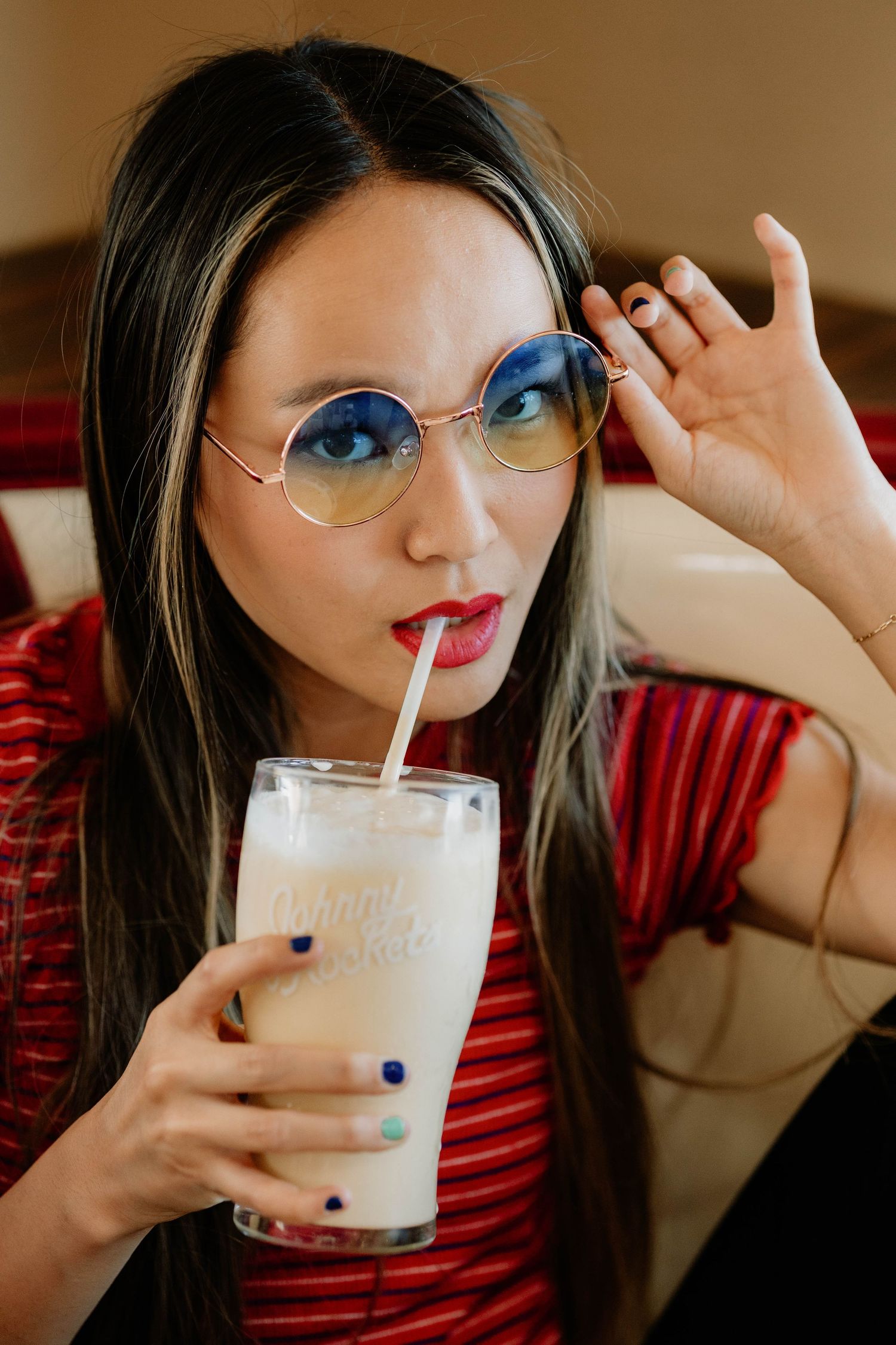 Series of photos showing someone sipping a milkshake while wearing retro sunglasses.