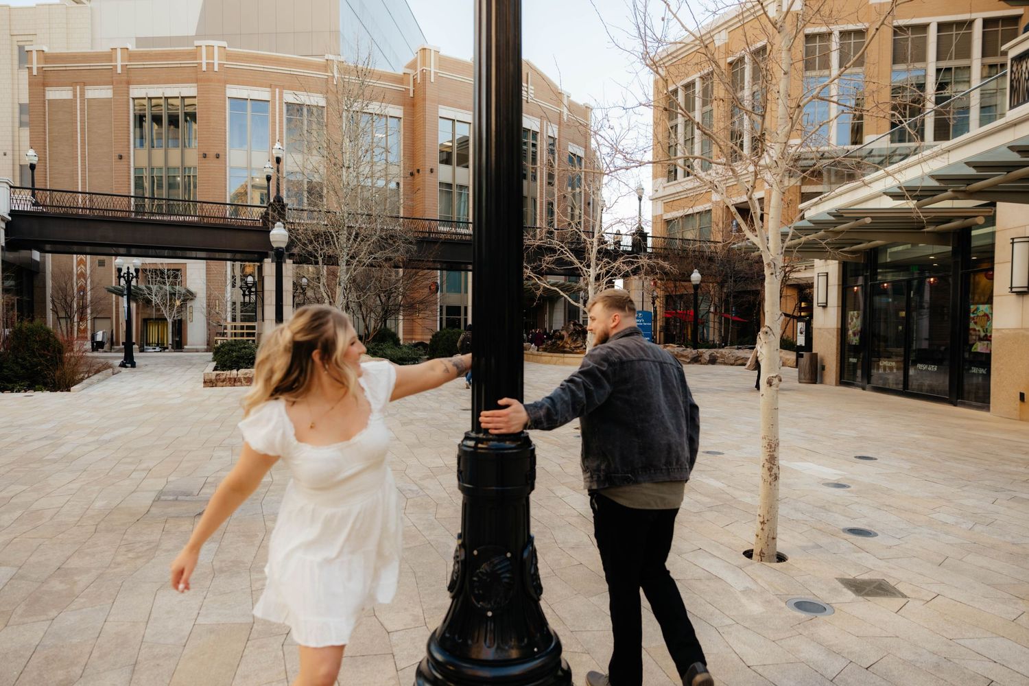 Dancing couple silhouetted against urban architecture and lampposts.