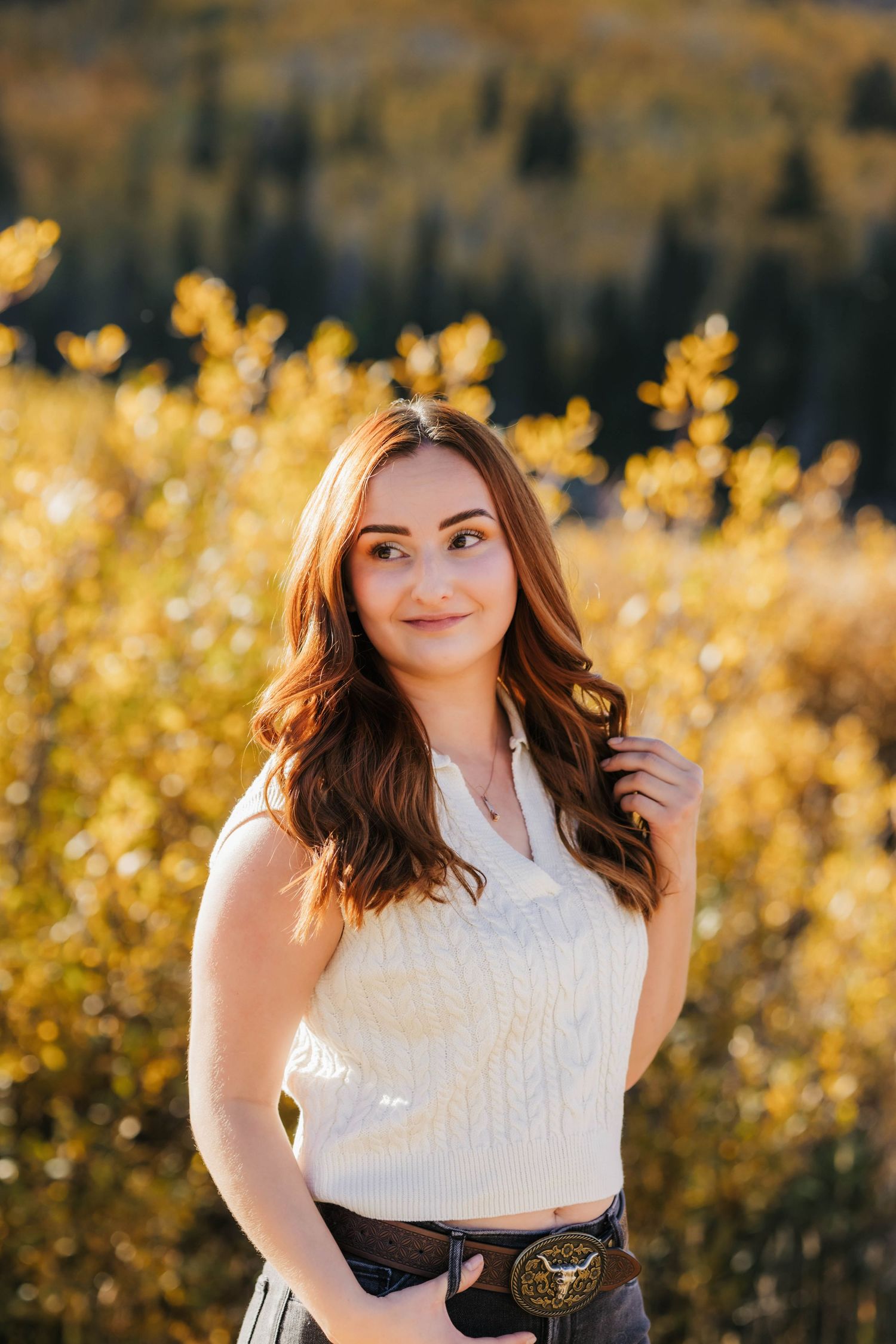 Autumn portrait session with golden wildflowers in mountain landscape.
