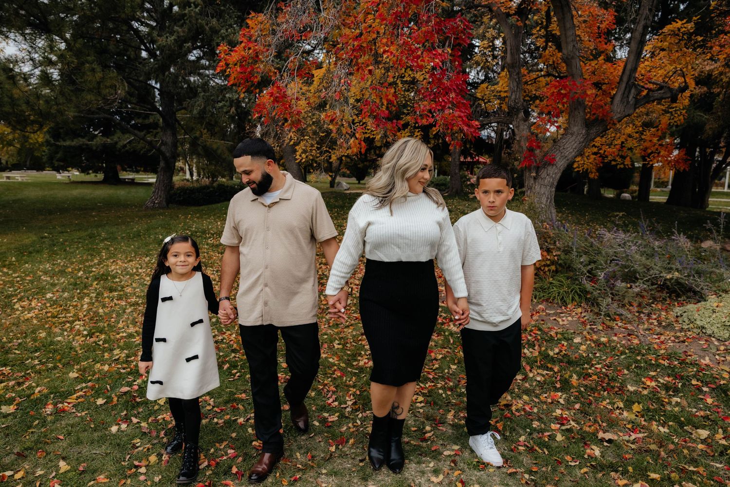Family enjoying a beautiful autumn day together in a park with vibrant fall foliage.