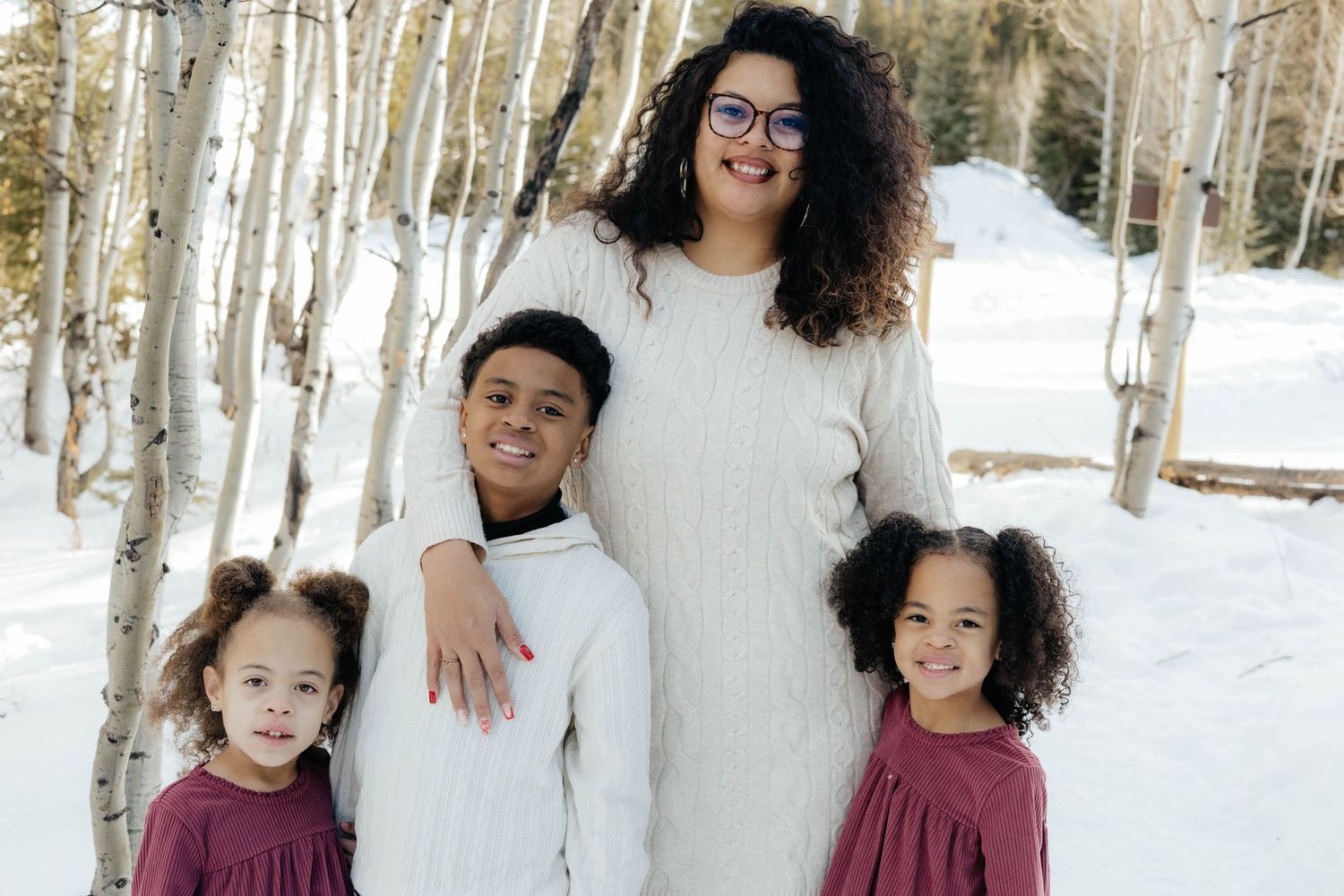 Winter family portraits among snow-covered aspen trees.