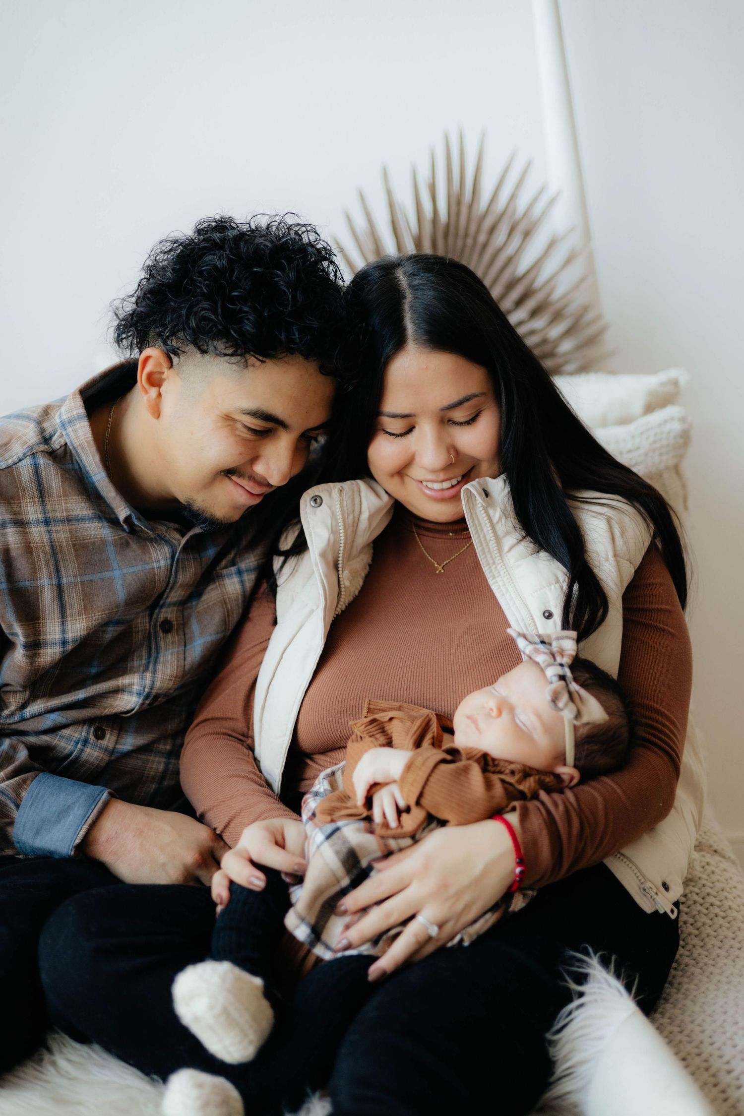 A cozy indoor family photo showing tender moments with a newborn baby.