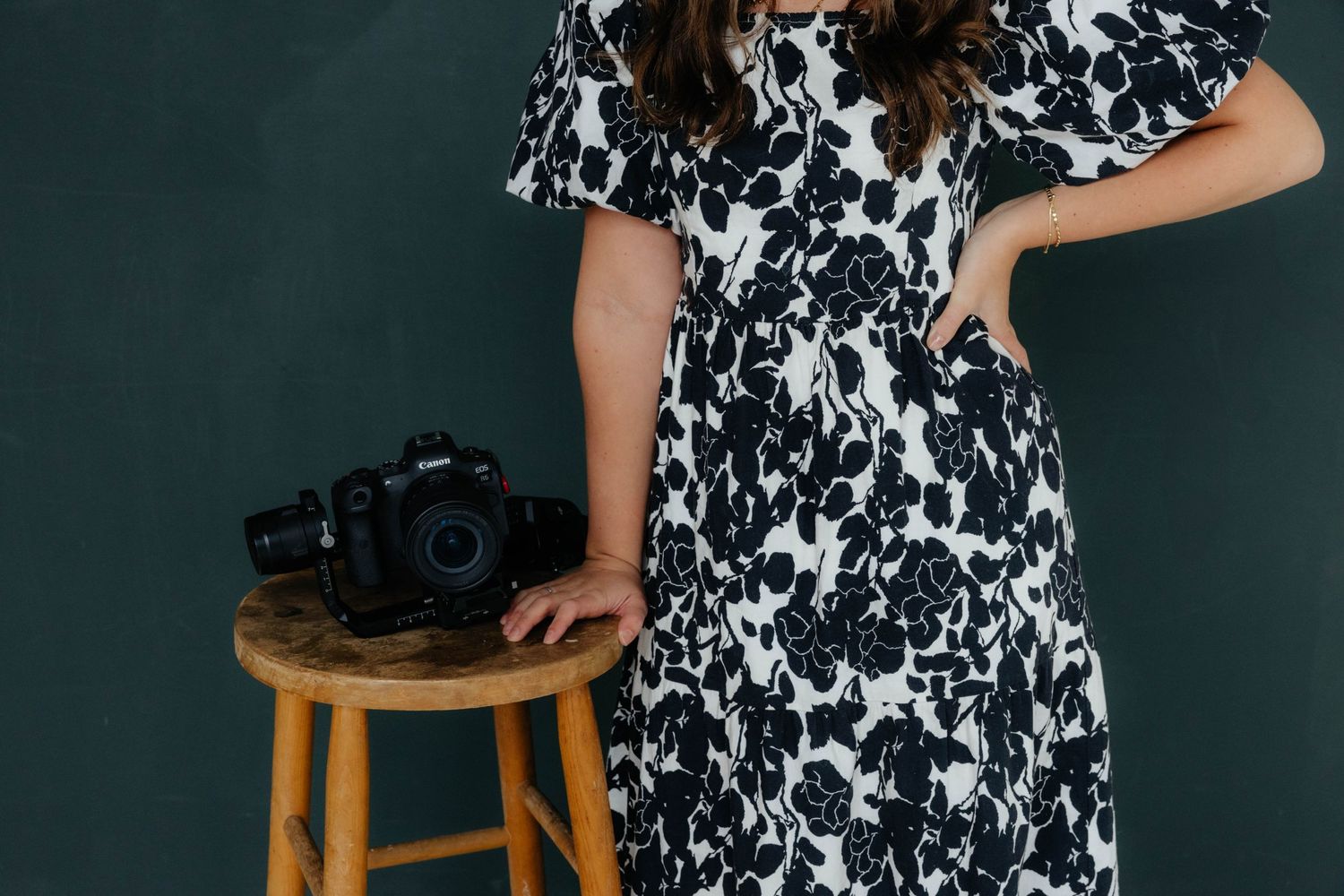 Detail shots of camera equipment with person wearing black and white floral pattern dress.