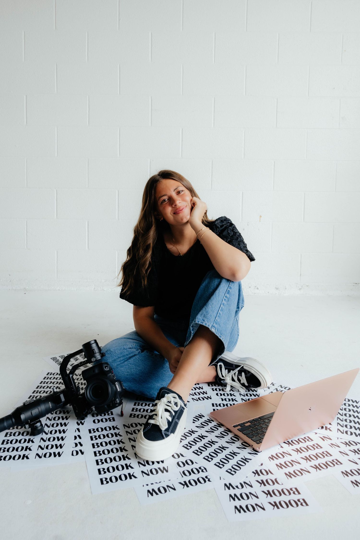 A casual portrait session with a laptop and printed materials on a patterned blanket.