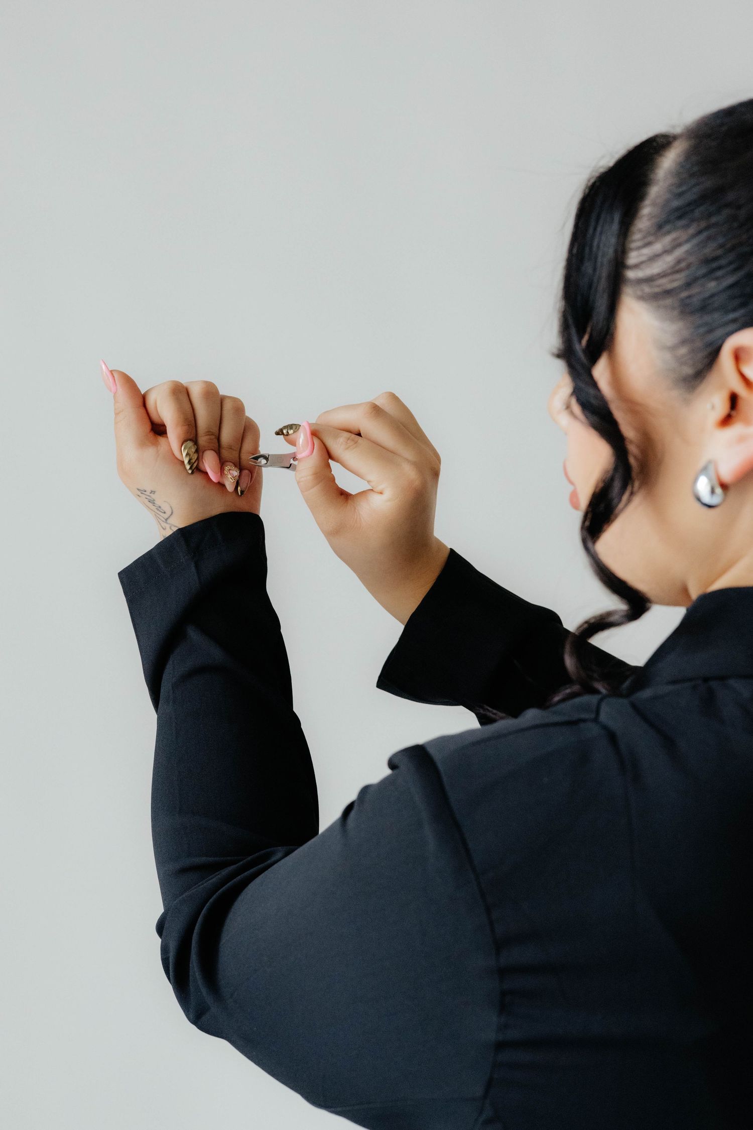 Person in black blazer adjusts something while facing away from camera.