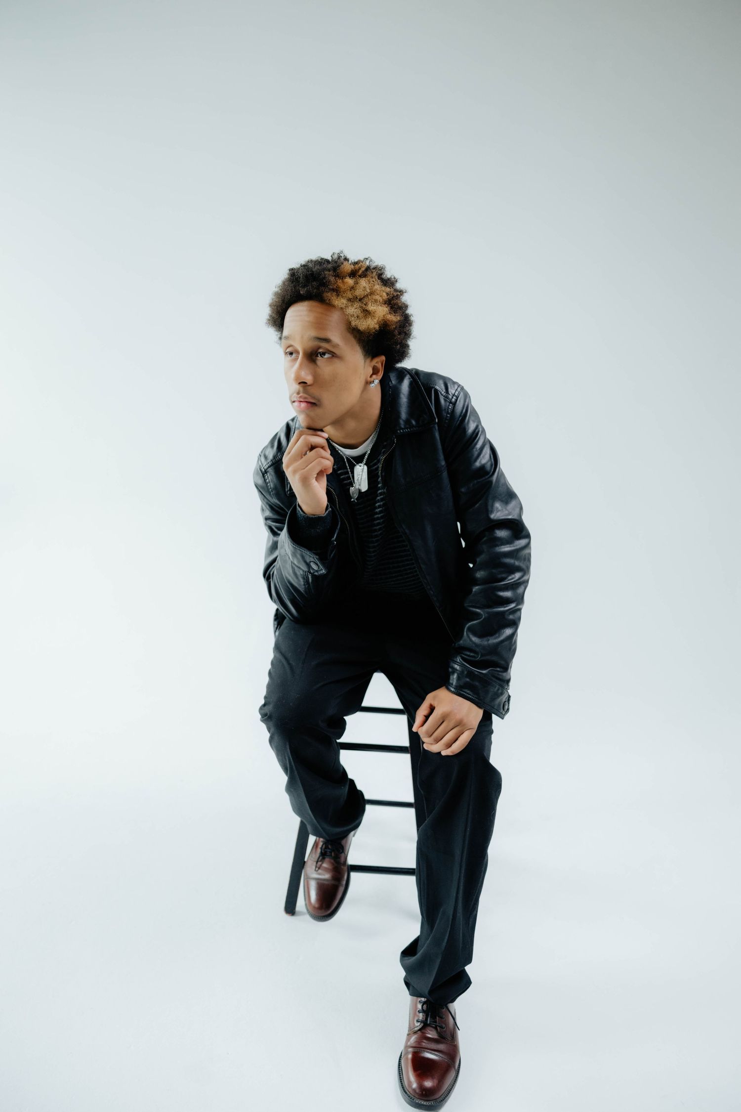 Artistic portrait series of someone in black attire posed from different angles on white background.
