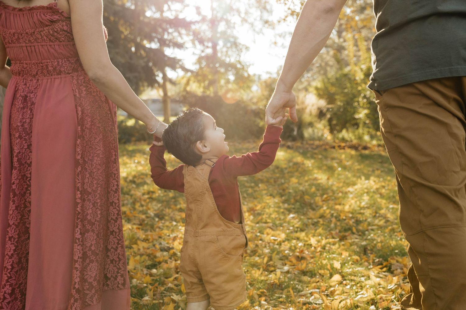 Candid family moments captured in warm sunlight with fall colors.