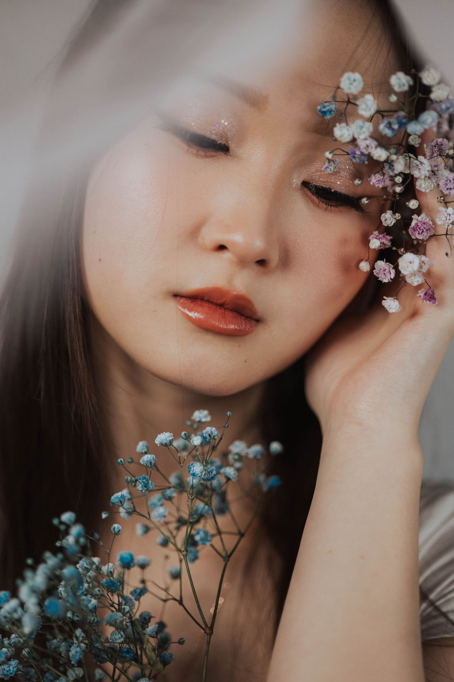 Dreamy close-up portrait with delicate baby's breath flowers creating an ethereal effect.