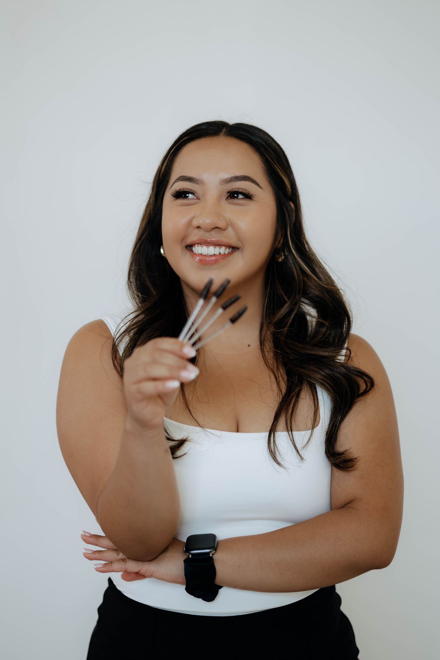 Portrait session against light background wearing white top.