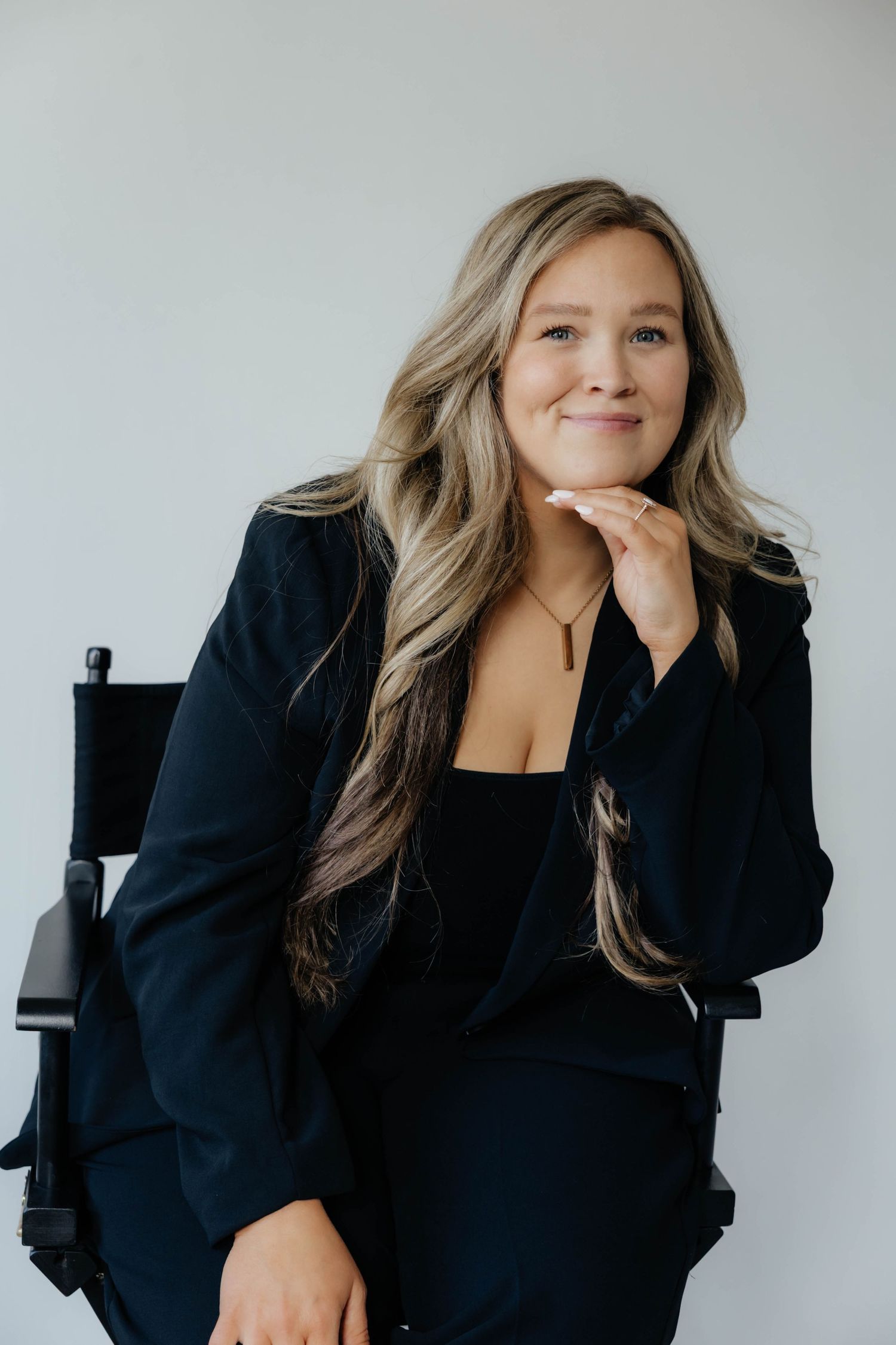 Professional headshots of a person in black blazer against white background showing different expressions.