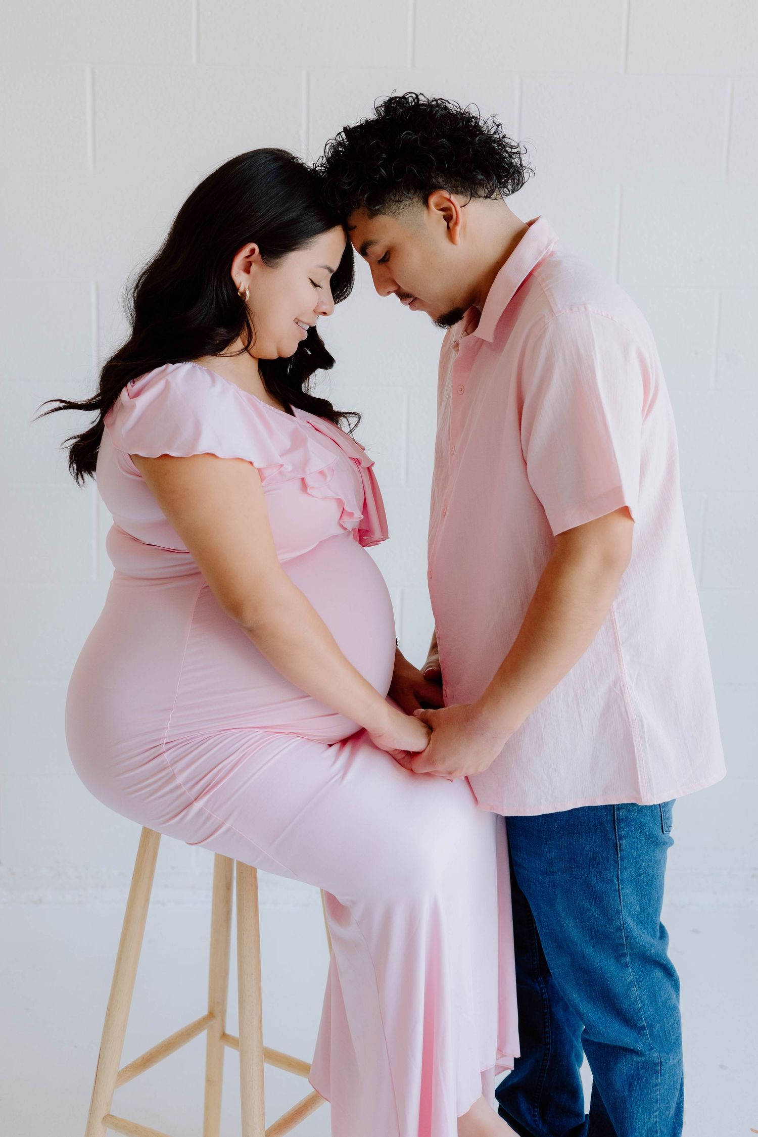 Tender maternity moments captured in soft pink tones.