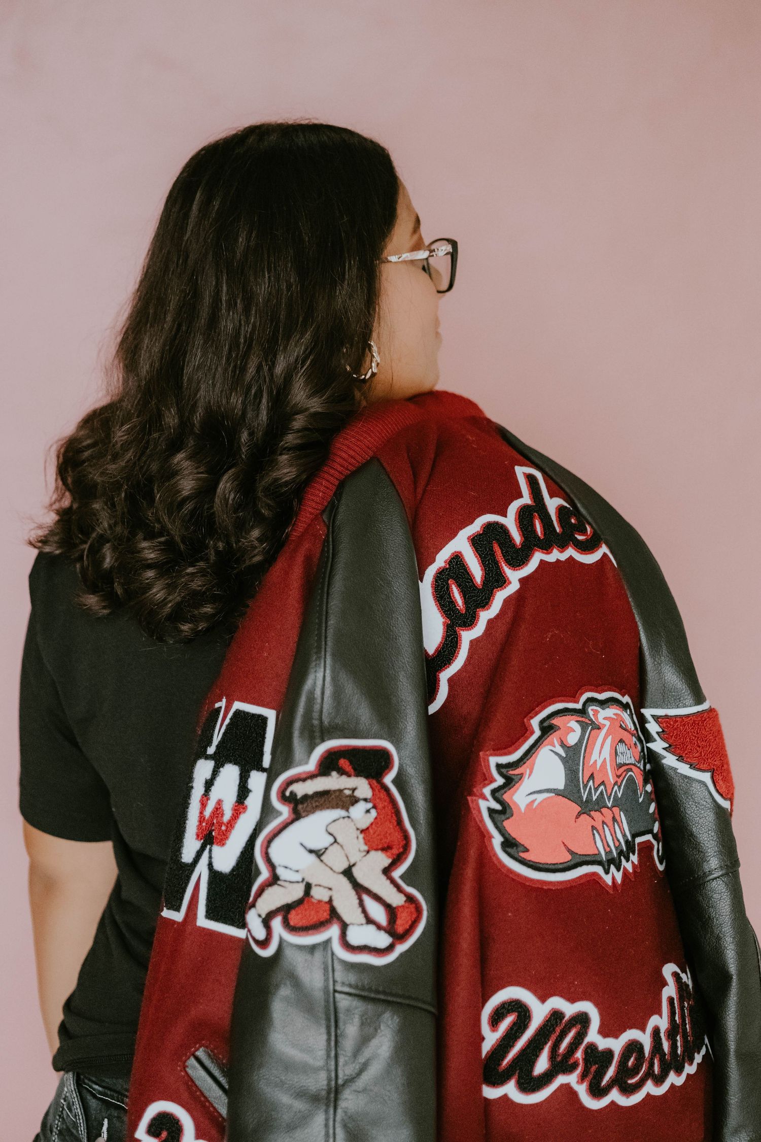 Close-up of red and black varsity jacket with mascot logo design.