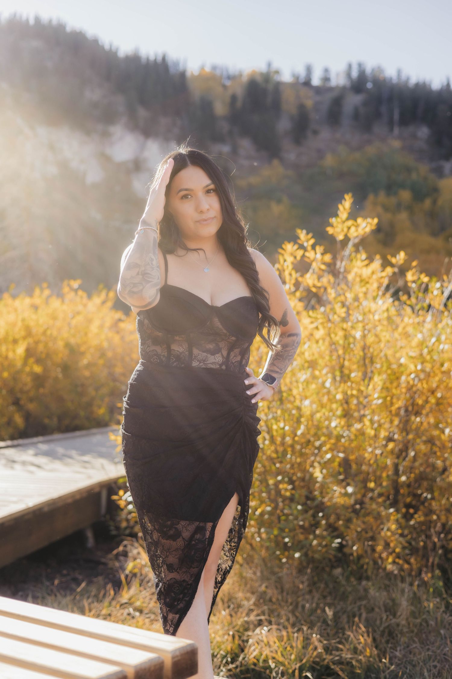 A black lace dress photoshoot in front of yellow wildflowers during golden hour.