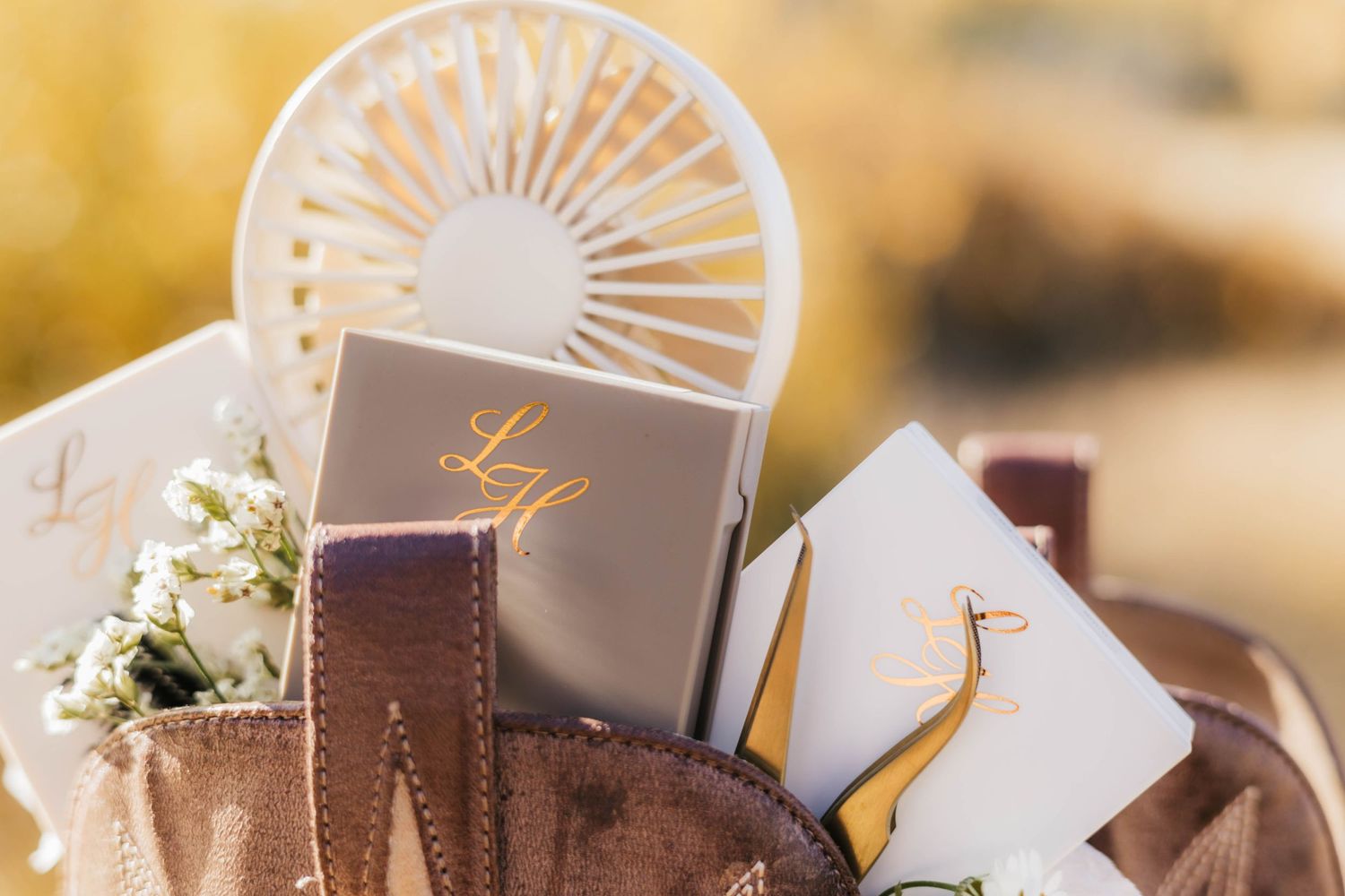 Decorative fan and stationery items arranged on a light colored surface with elegant styling.