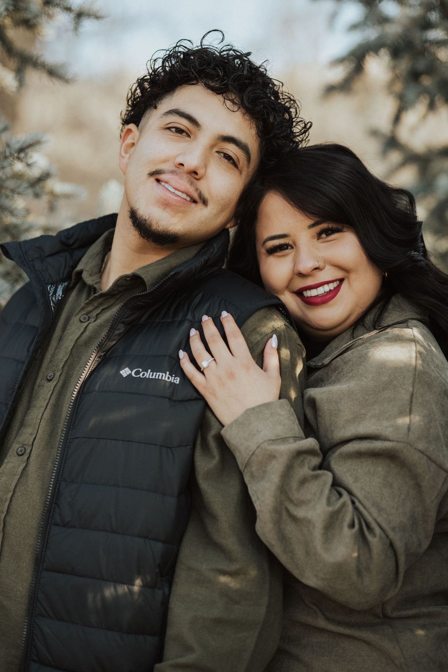 Cozy winter couple portraits in matching dark jackets.