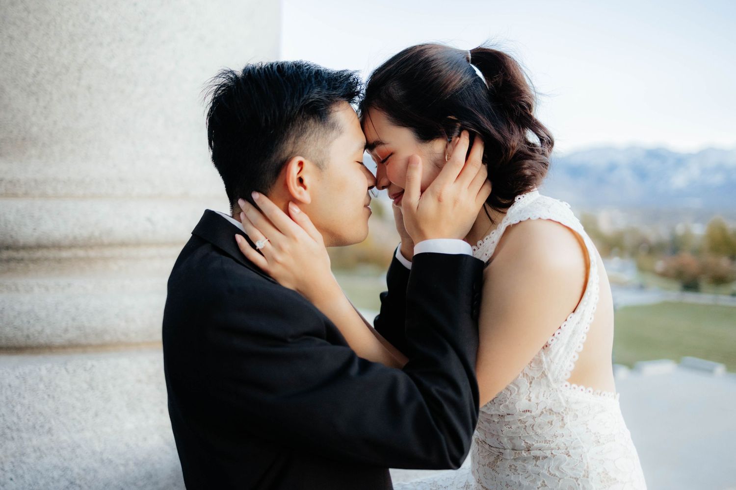 An intimate wedding photoshoot with a couple in formal attire by a lake.