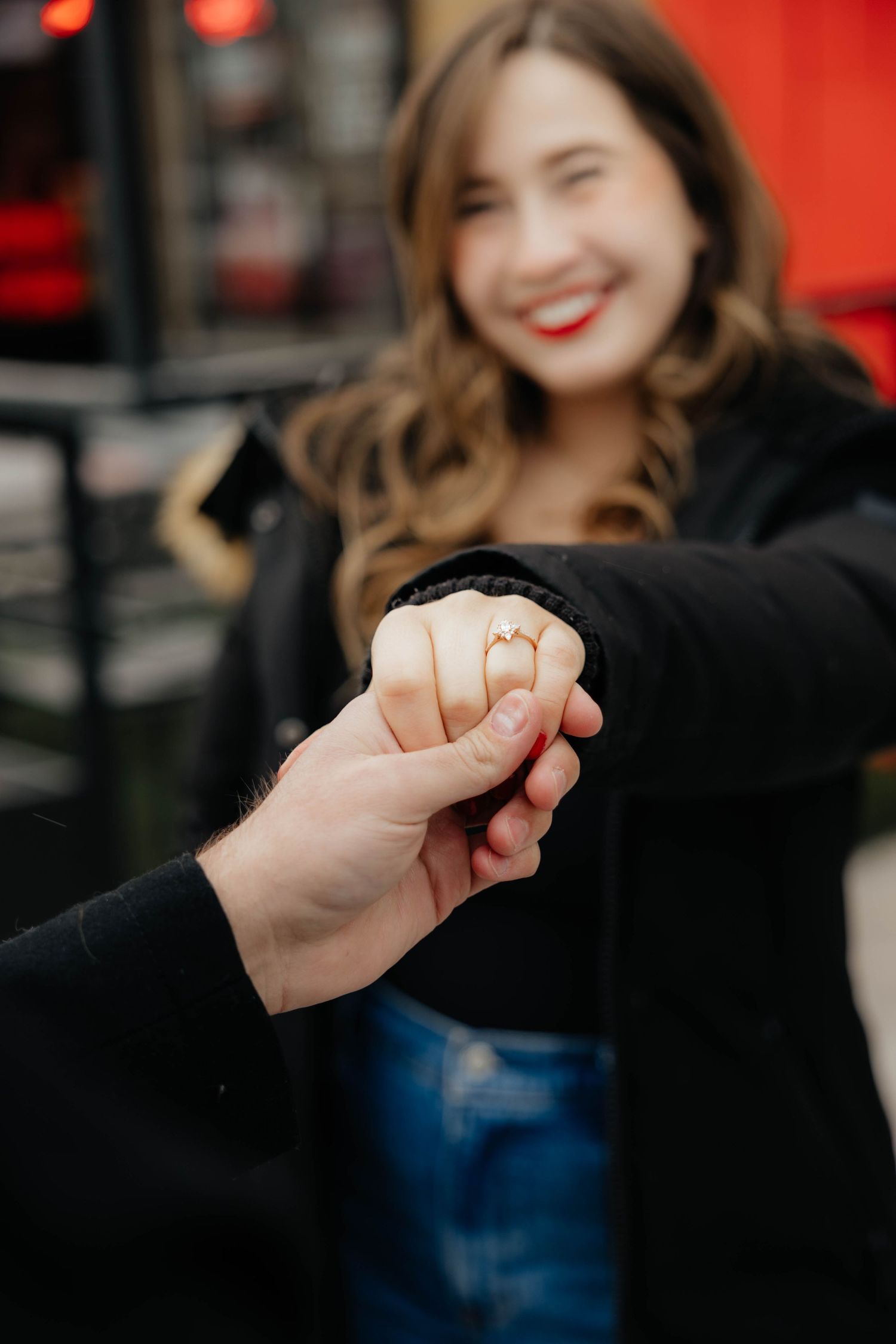Close-up engagement ring photography sequence with hands against red background.