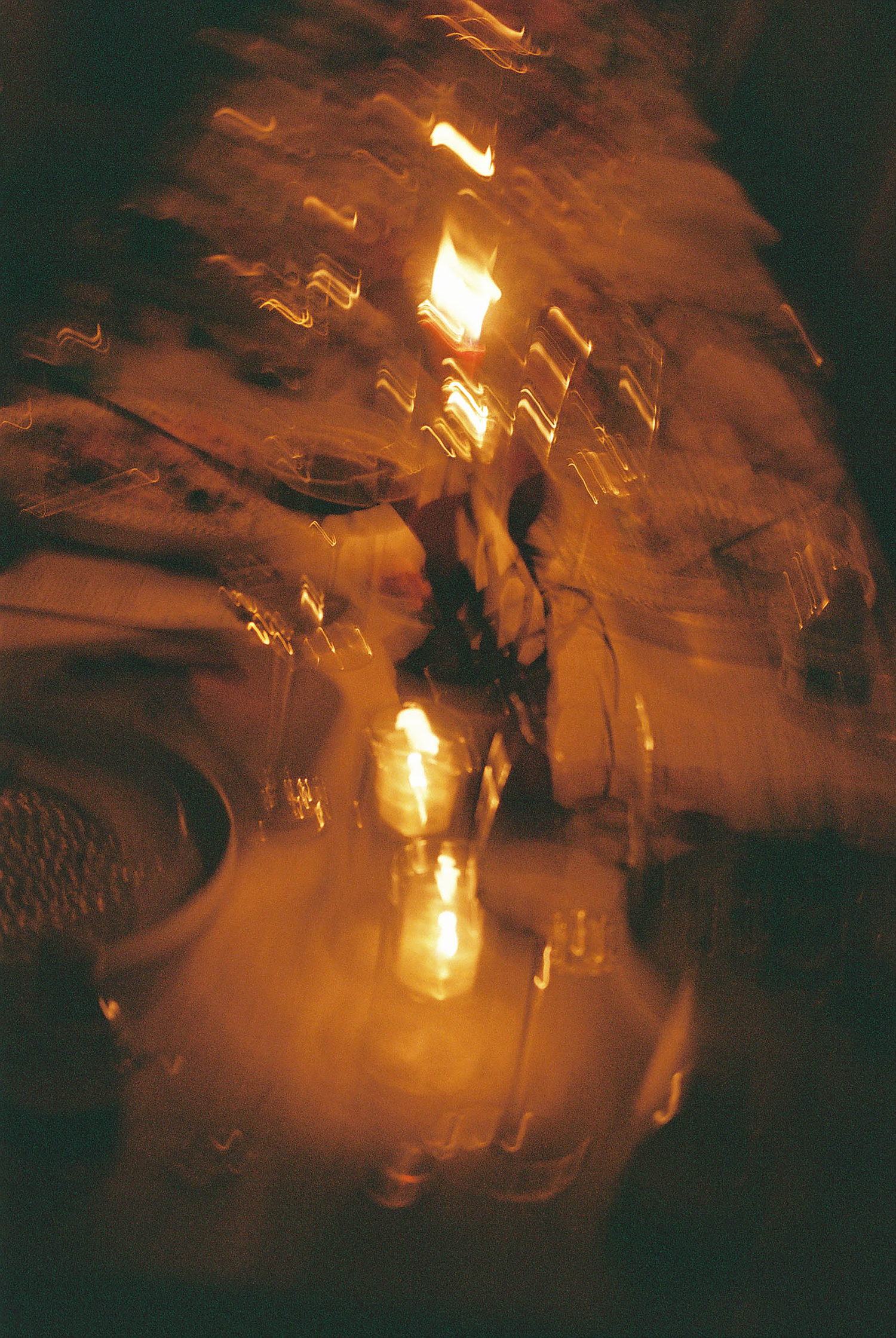 Abstract blurred motion photograph capturing warm golden light streaks at a wedding reception celebration.