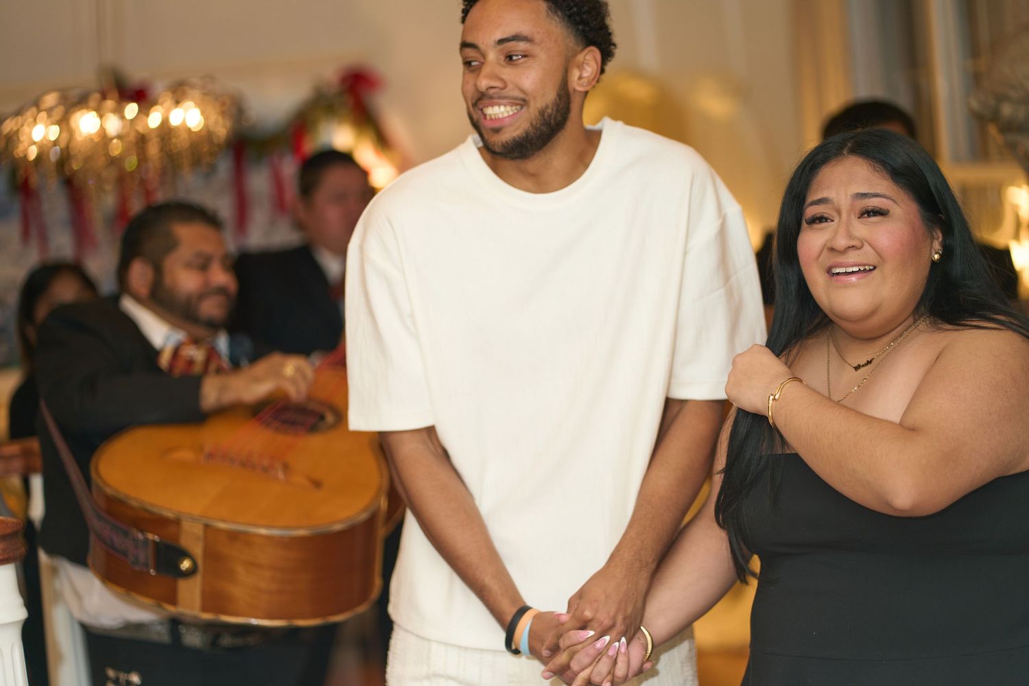 A joyful moment captured at an indoor celebration with warm lighting and decorative elements.