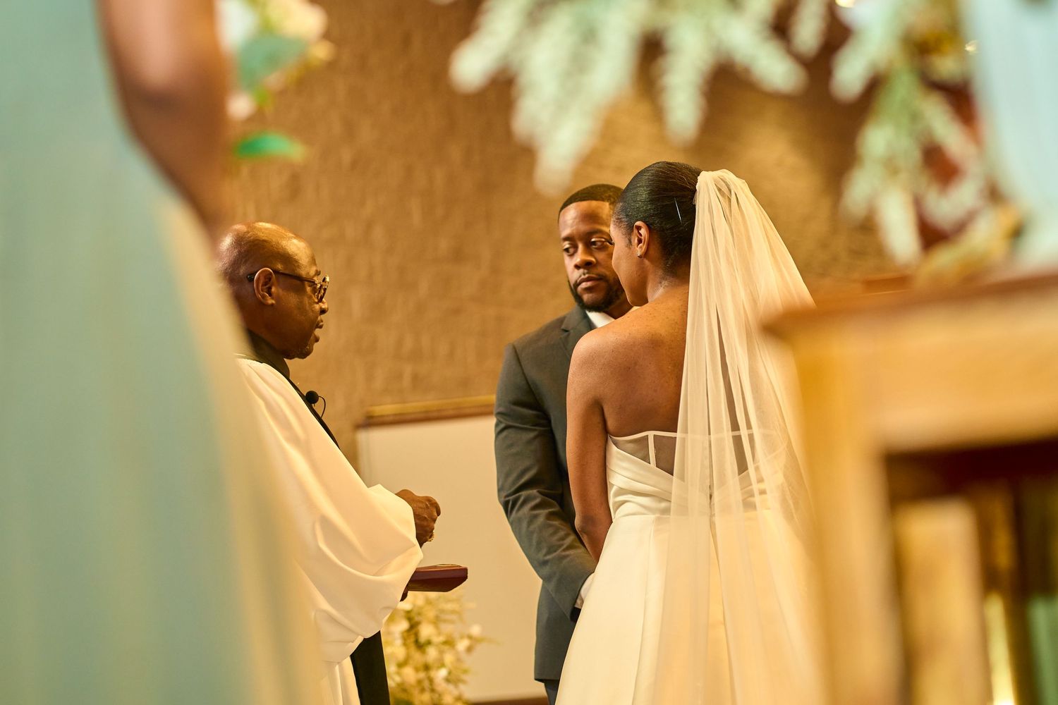 A wedding ceremony moment captured in warm lighting with elegant decor.