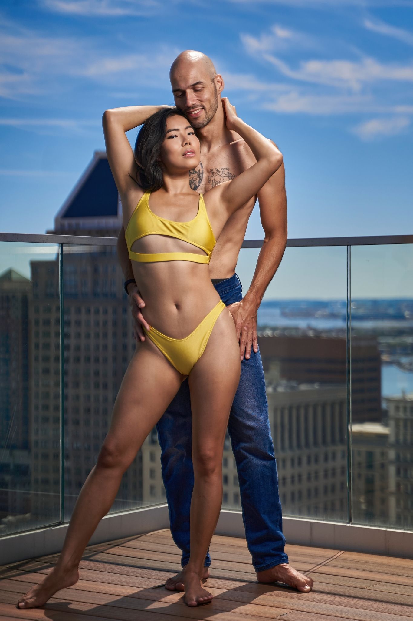Rooftop photography session with bright yellow swimwear against city views.