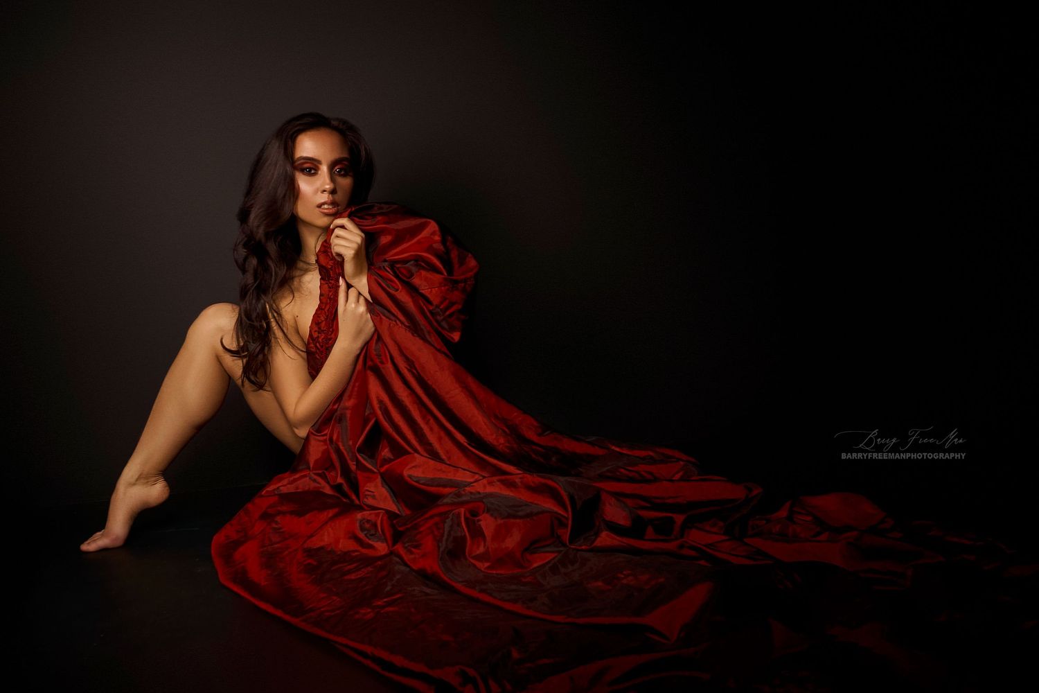 Dramatic fashion series with flowing red fabric against dark background.
