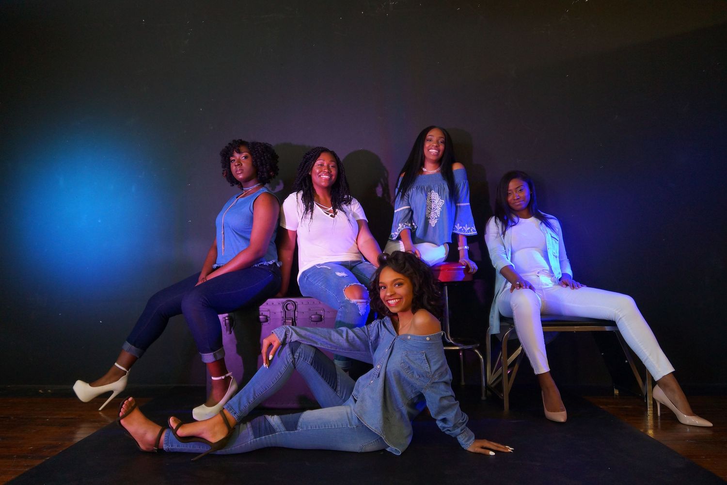Dance group performing on dark stage with blue lighting effects.
