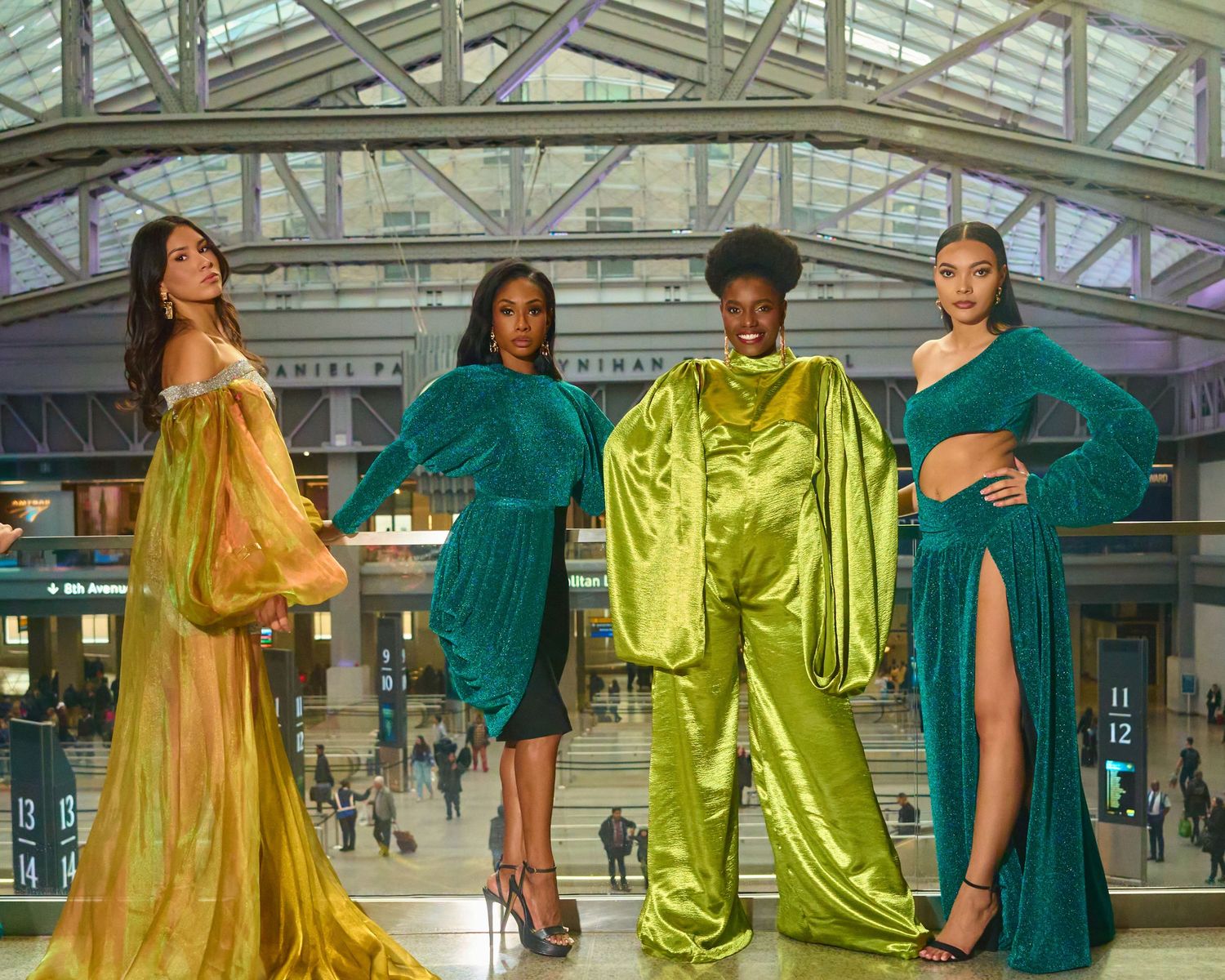 Fashion editorial with models in flowing yellow and teal gowns in modern glass architecture.