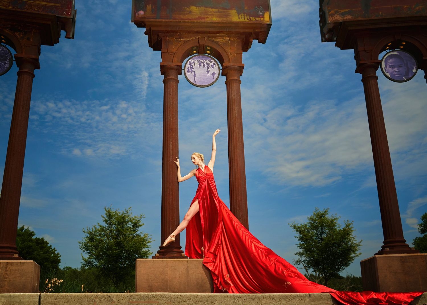 Red flowing fabric draped dramatically across an outdoor architectural setting.