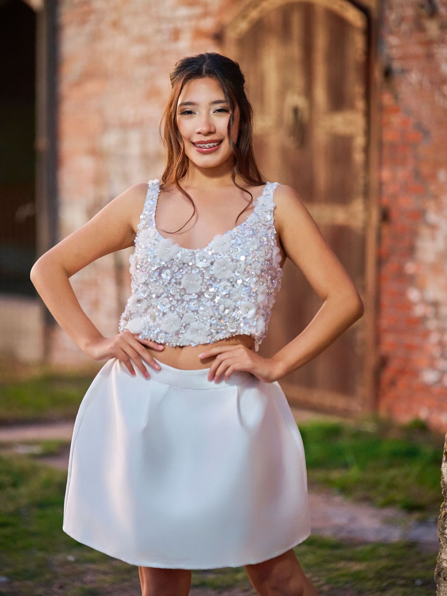 Elegant white lace dress portraits showcasing delicate details against brick walls.