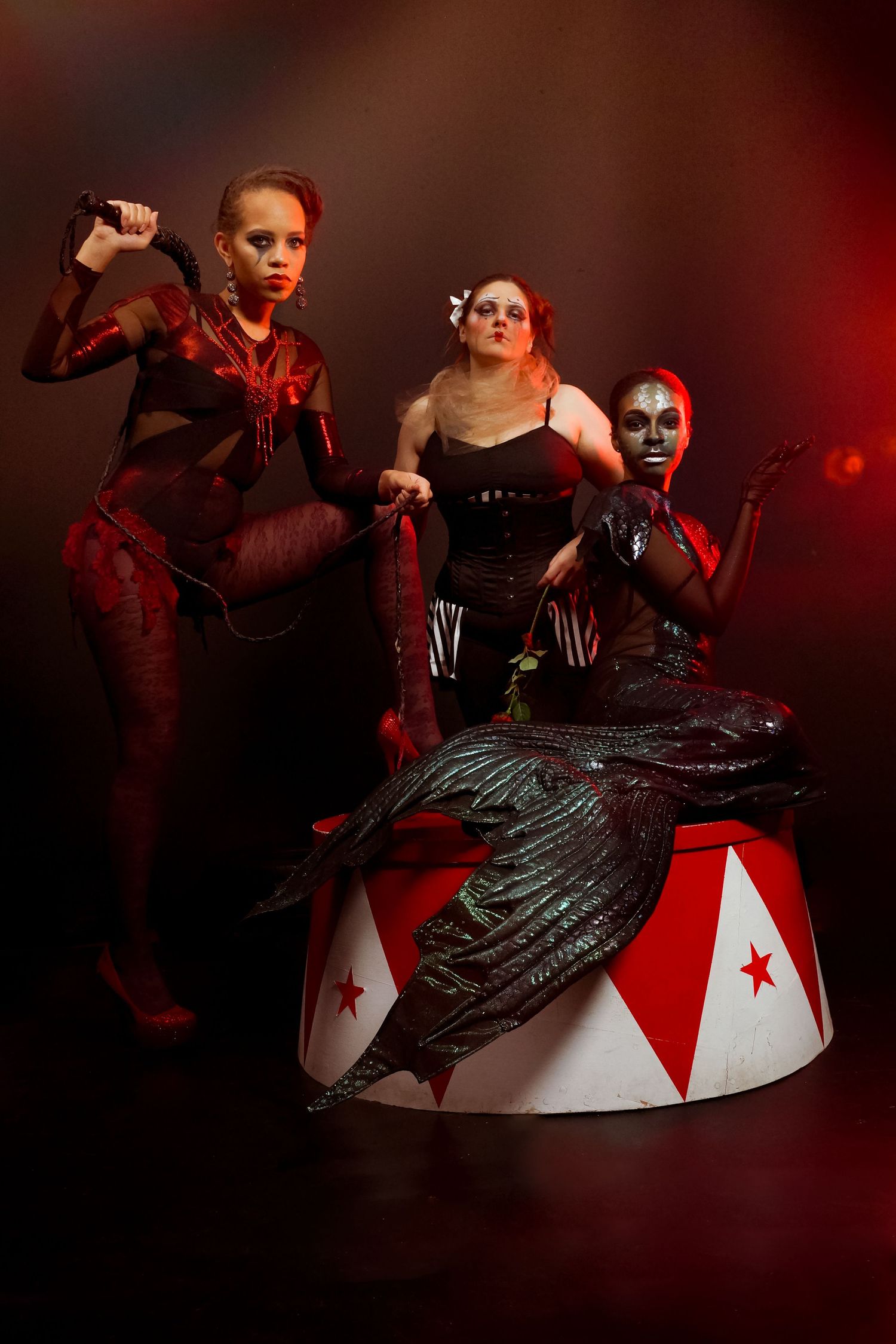 Dramatic dance performance with red lighting features elegant poses on a white and red platform.