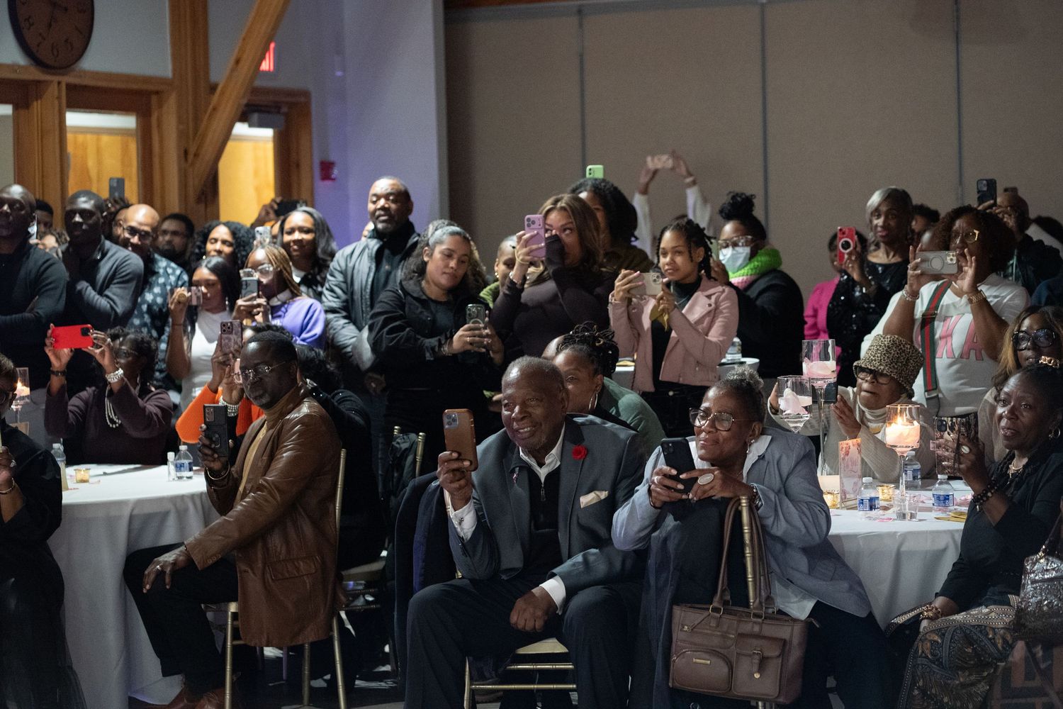 Crowd of guests watching and capturing special moment on their phones.