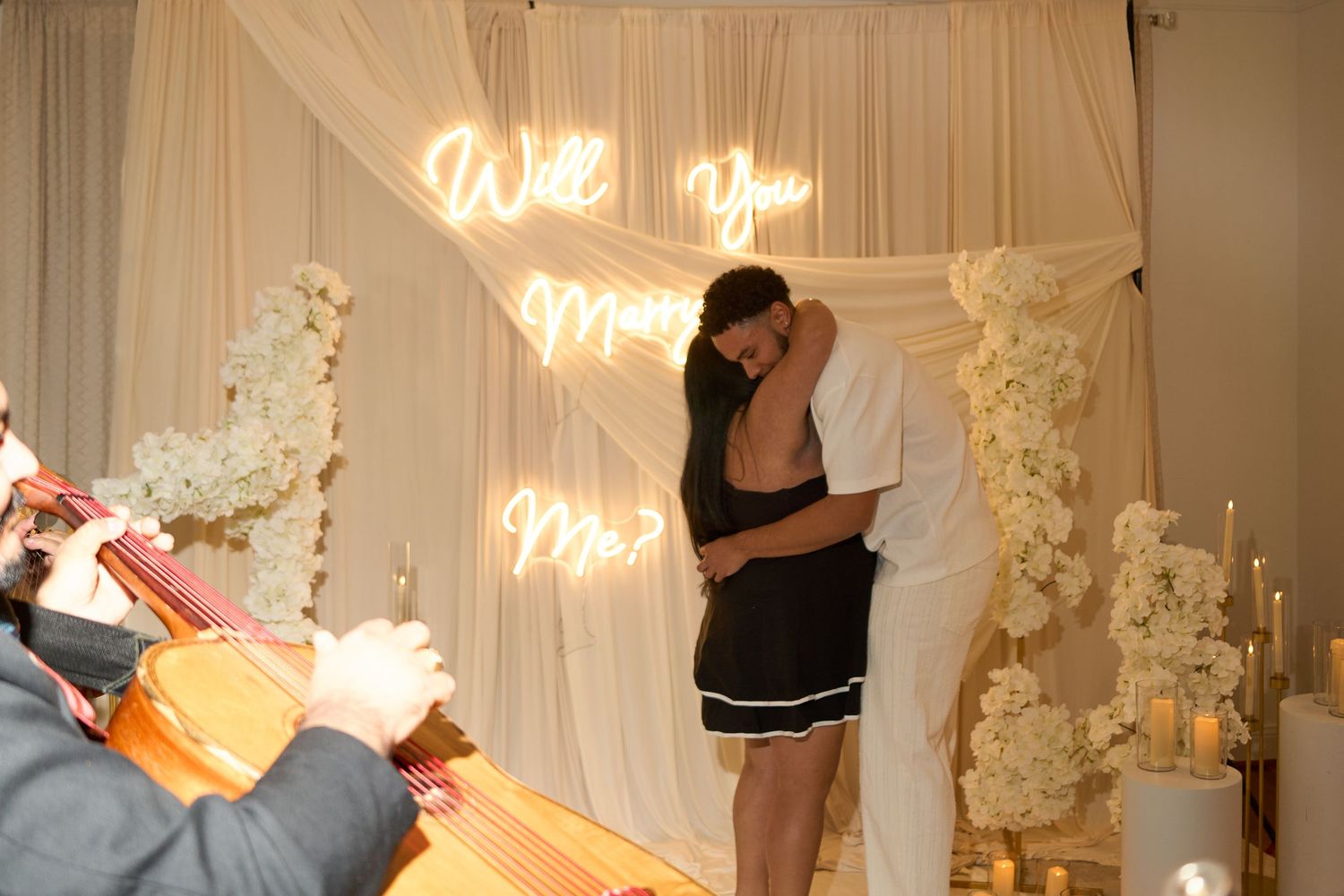 Wedding reception venue with warm lighting and white floral decorations.
