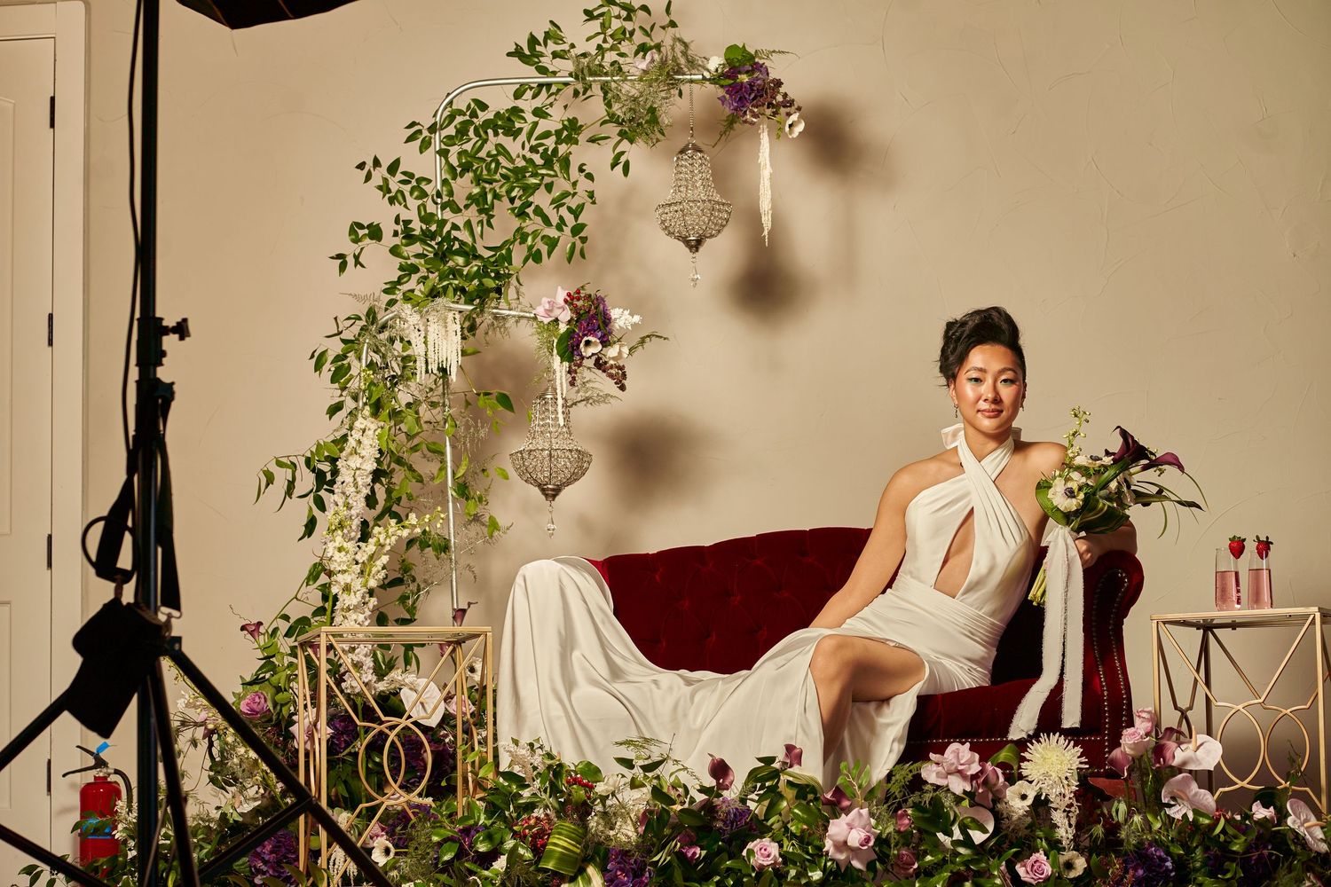 A bridal boudoir photo setup with floral arrangements and elegant furniture.