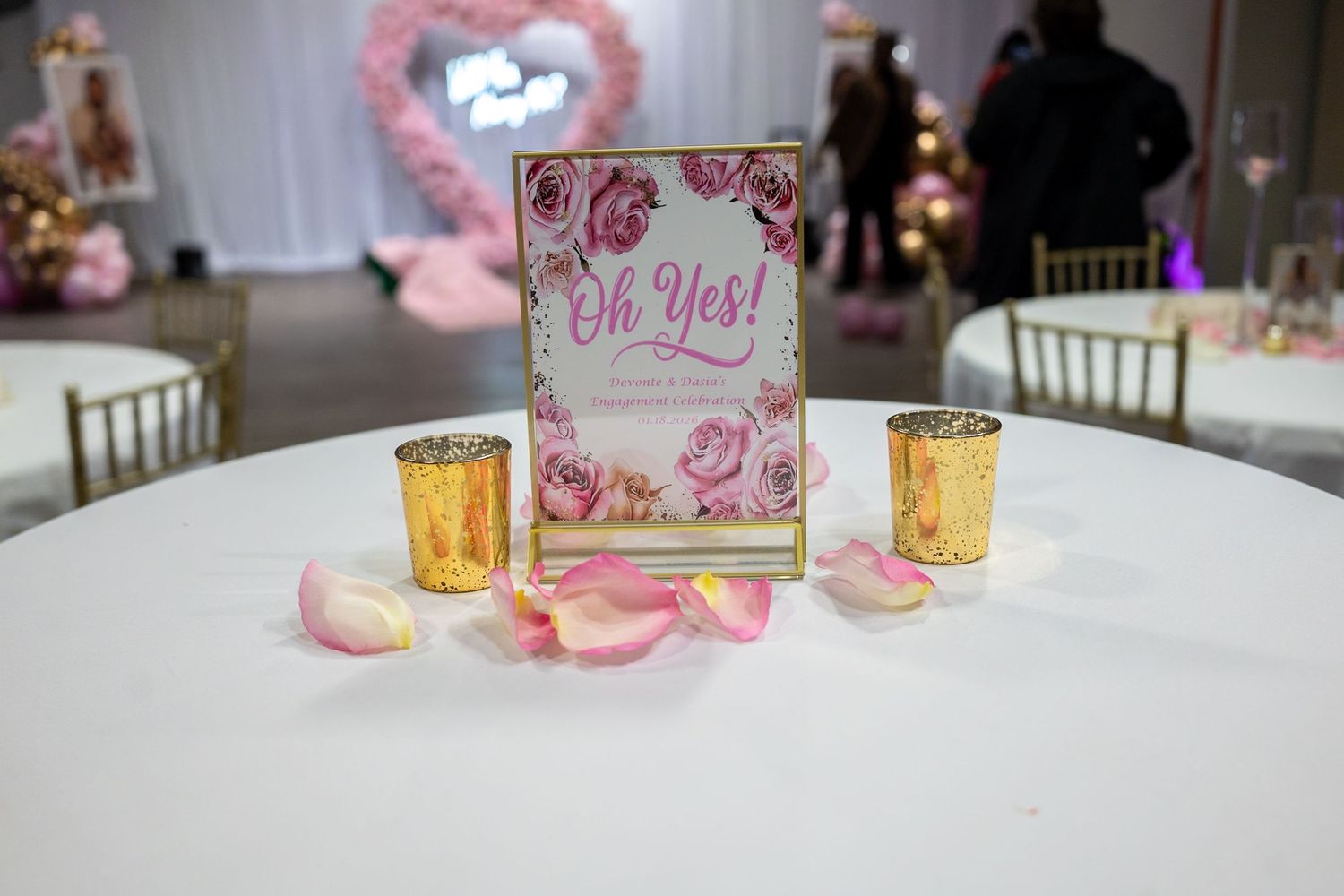 Elegant table settings with gold accents and pink floral decorations for a romantic celebration.