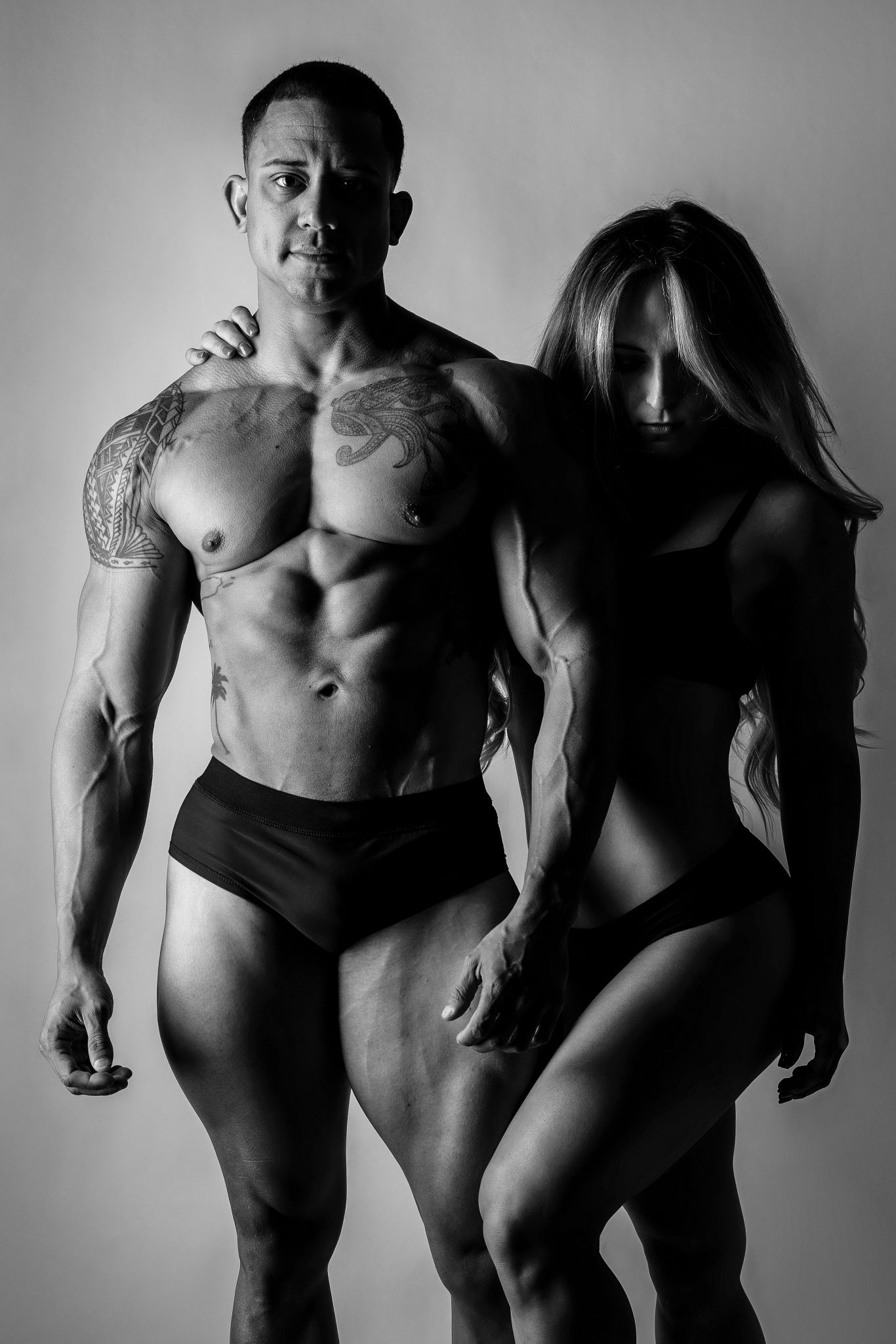 Dramatic black and white portrait of two figures in intimate poses.