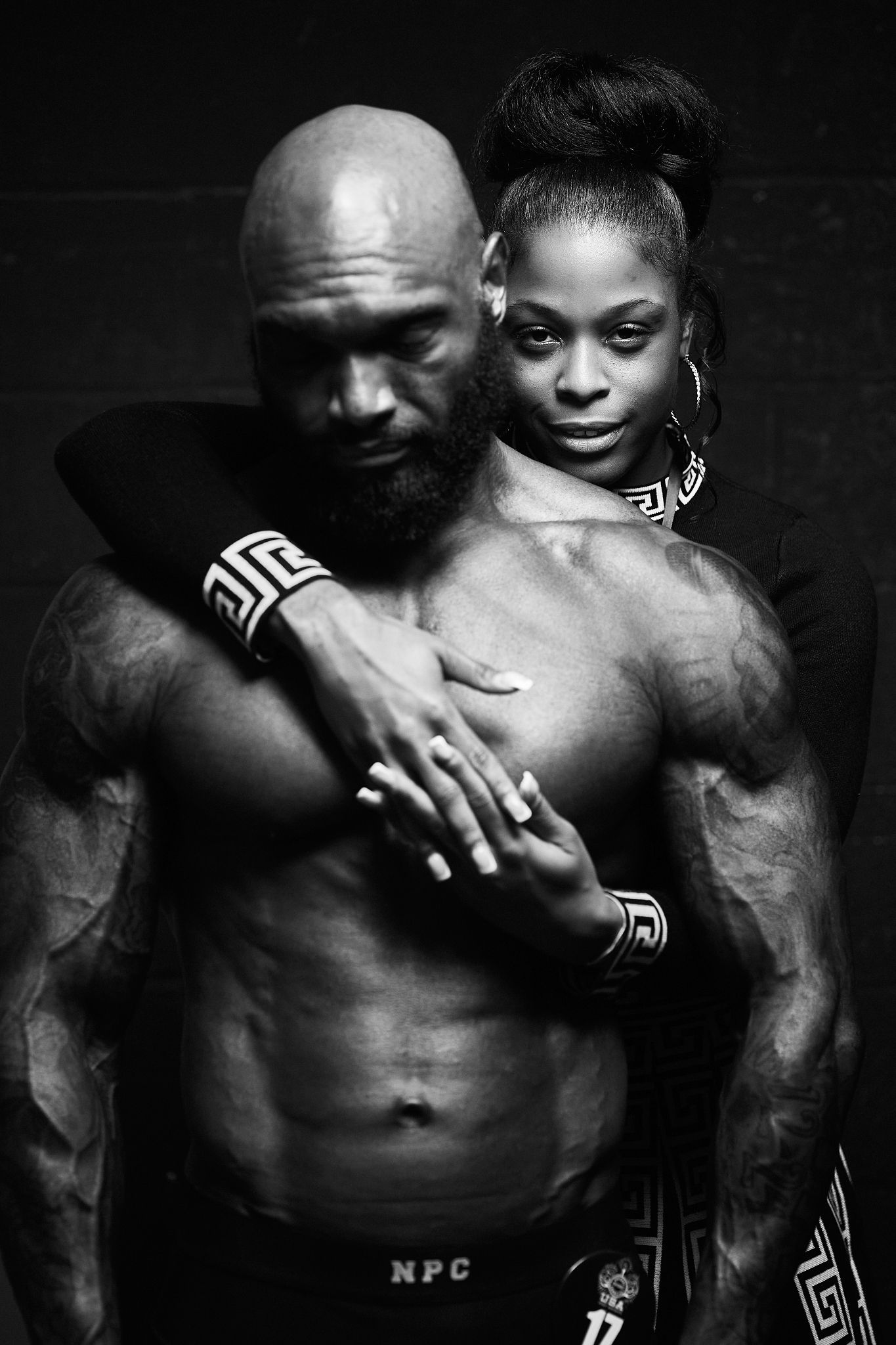 Intimate black and white portraits showing connection between two figures with tribal-style body art.