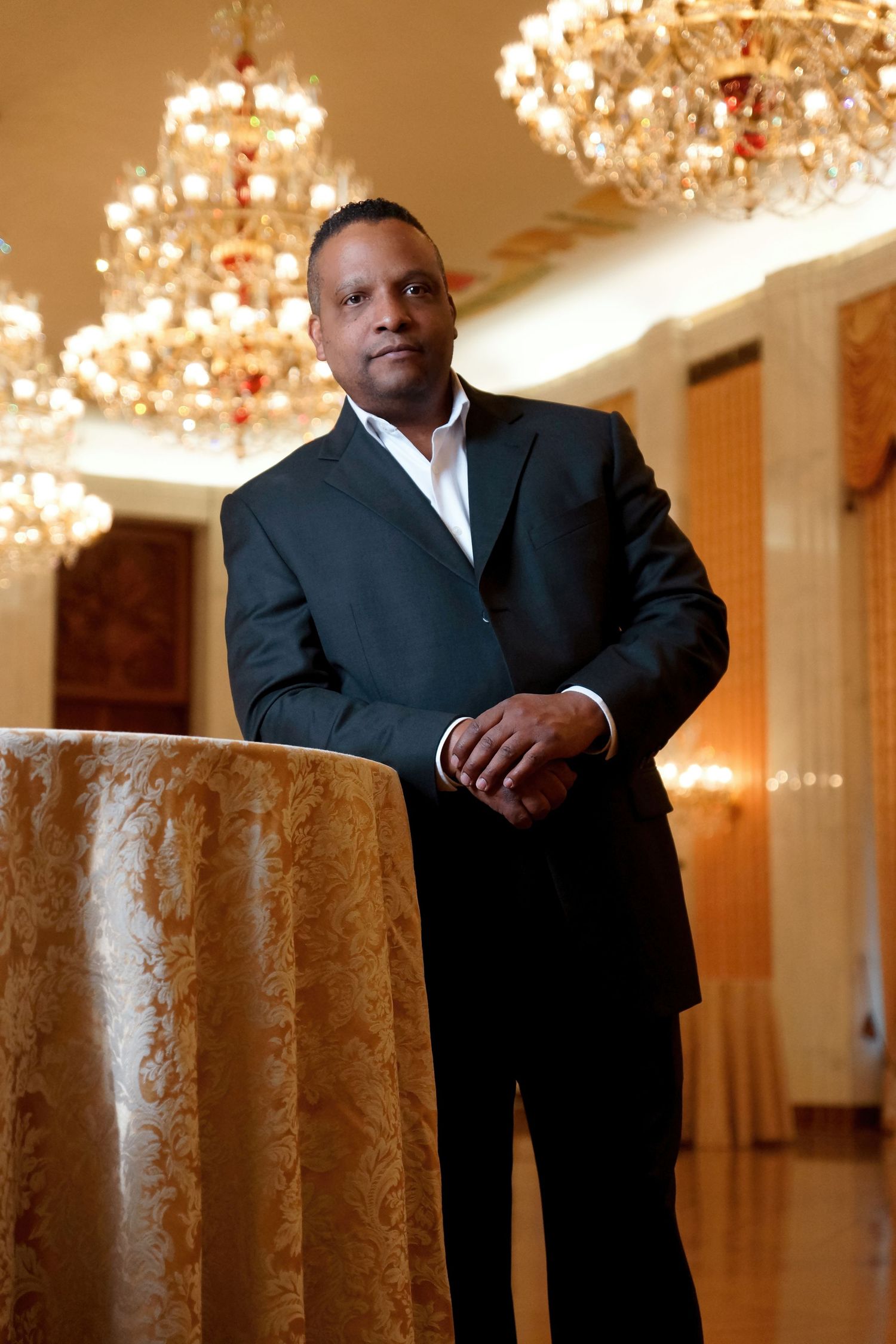 Professional portrait series in elegant venue with crystal chandeliers and warm lighting.