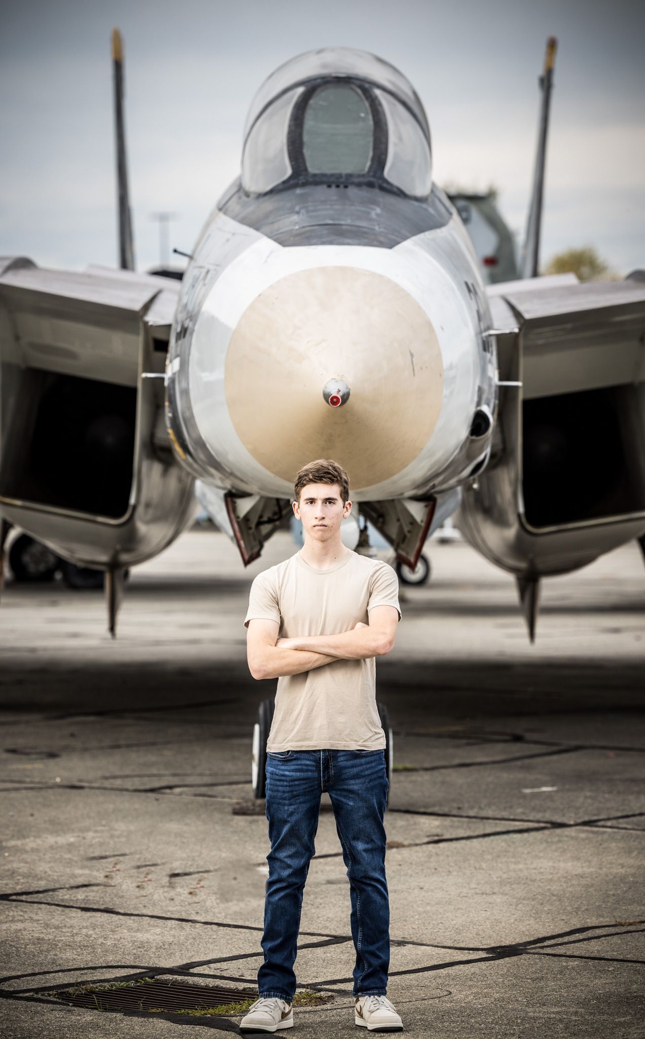 Senior Photos - Standing centered in front of military jet aircraft nose on runway.