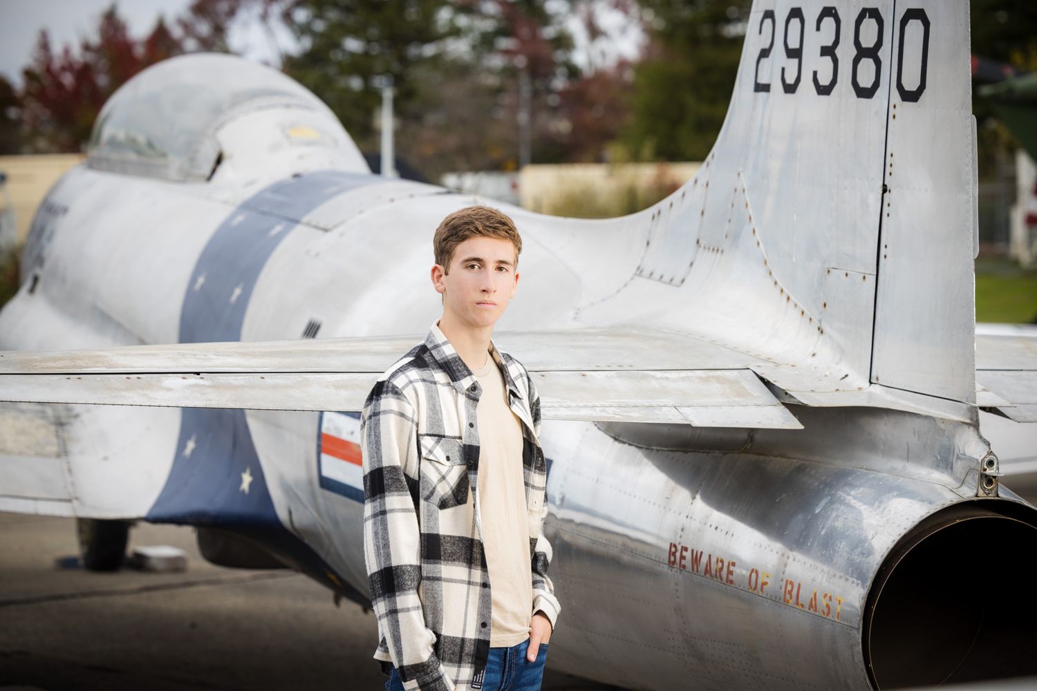 Senior Photos - Standing beside vintage training aircraft with tail number 29380 visible.